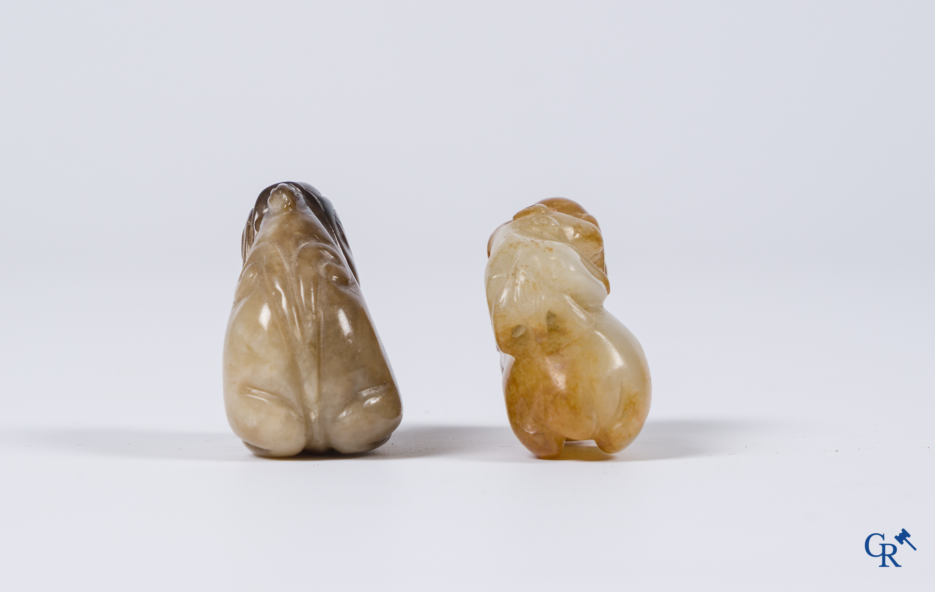 Aziatica. Een bleek celadon en roestbruin kleurige jade hertengroep en een bruinkleurig mythisch beest in jade.