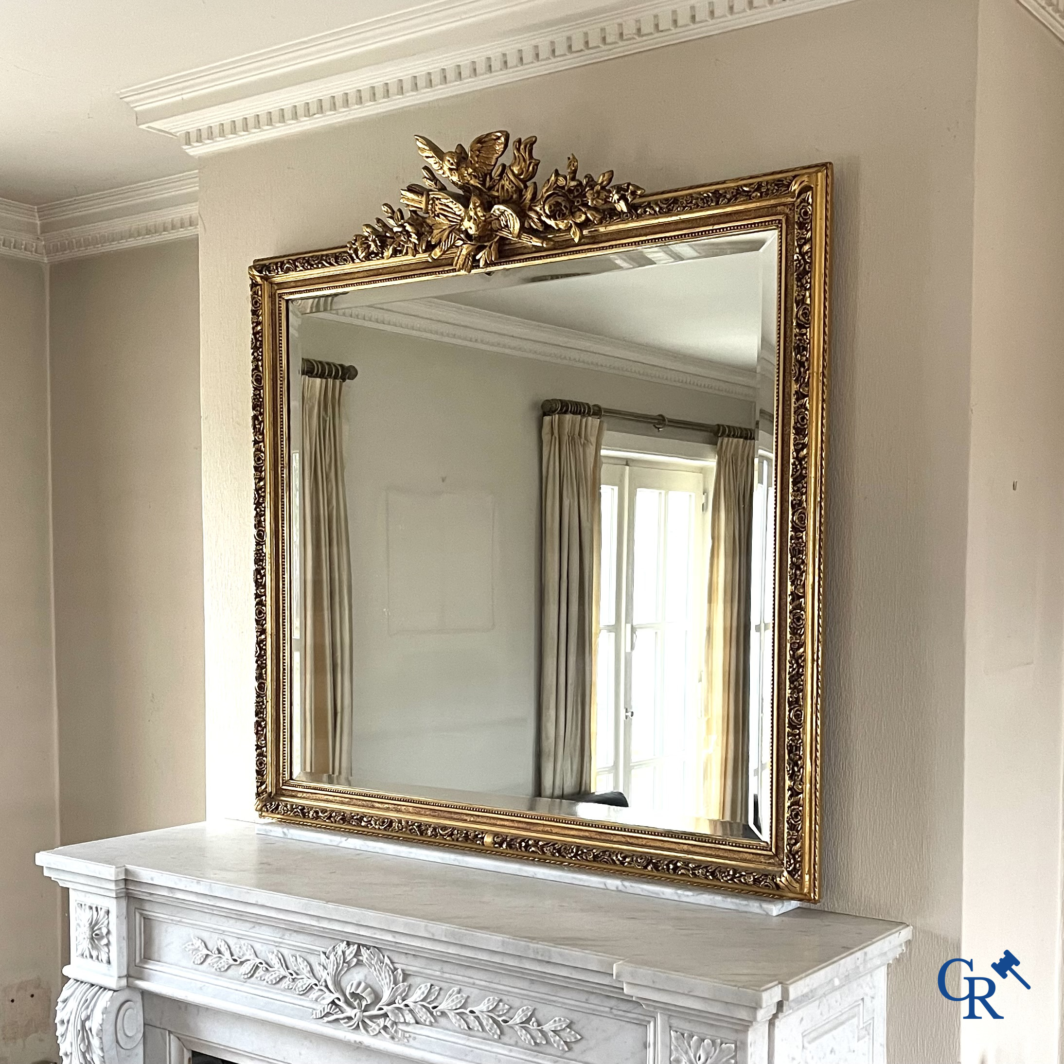 A large gilded fireplace mirror in LXVI style. Circa 1920.