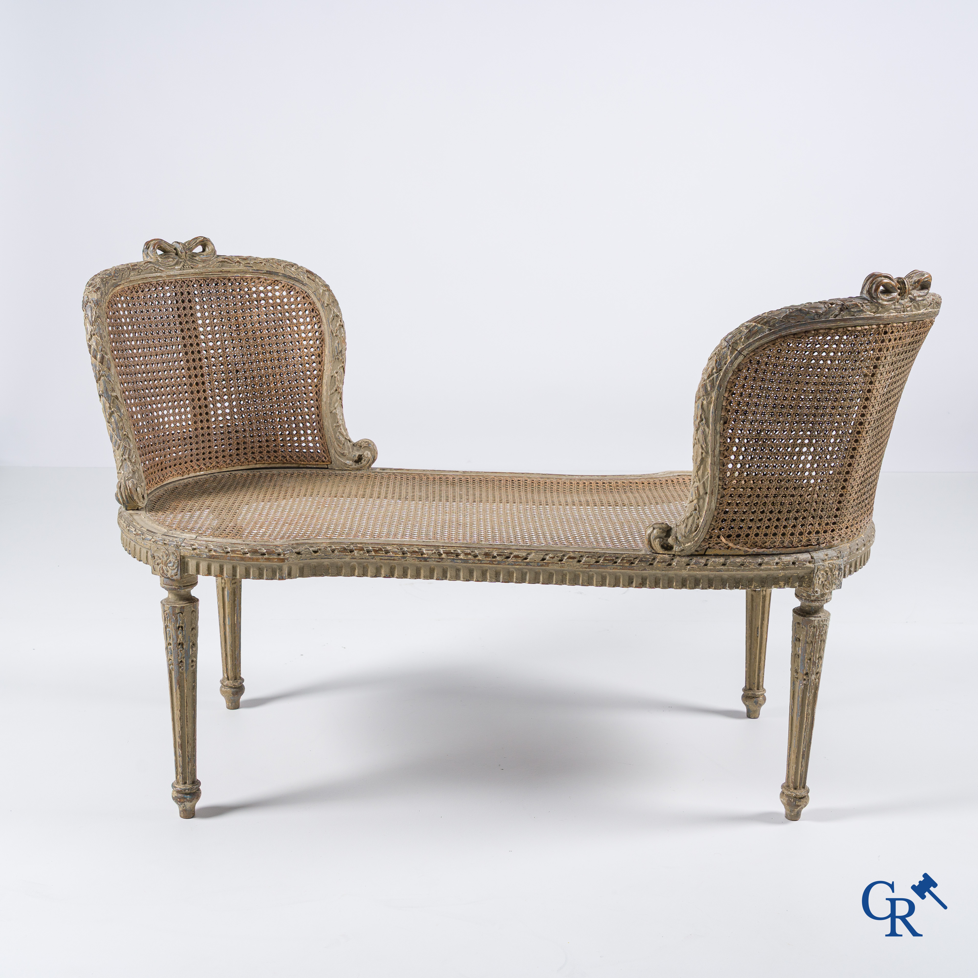 Epoque Louis XVI. Une banquette LXVI en bois sculpté à patine grise avec cannage. Fin du XVIIIème siècle.