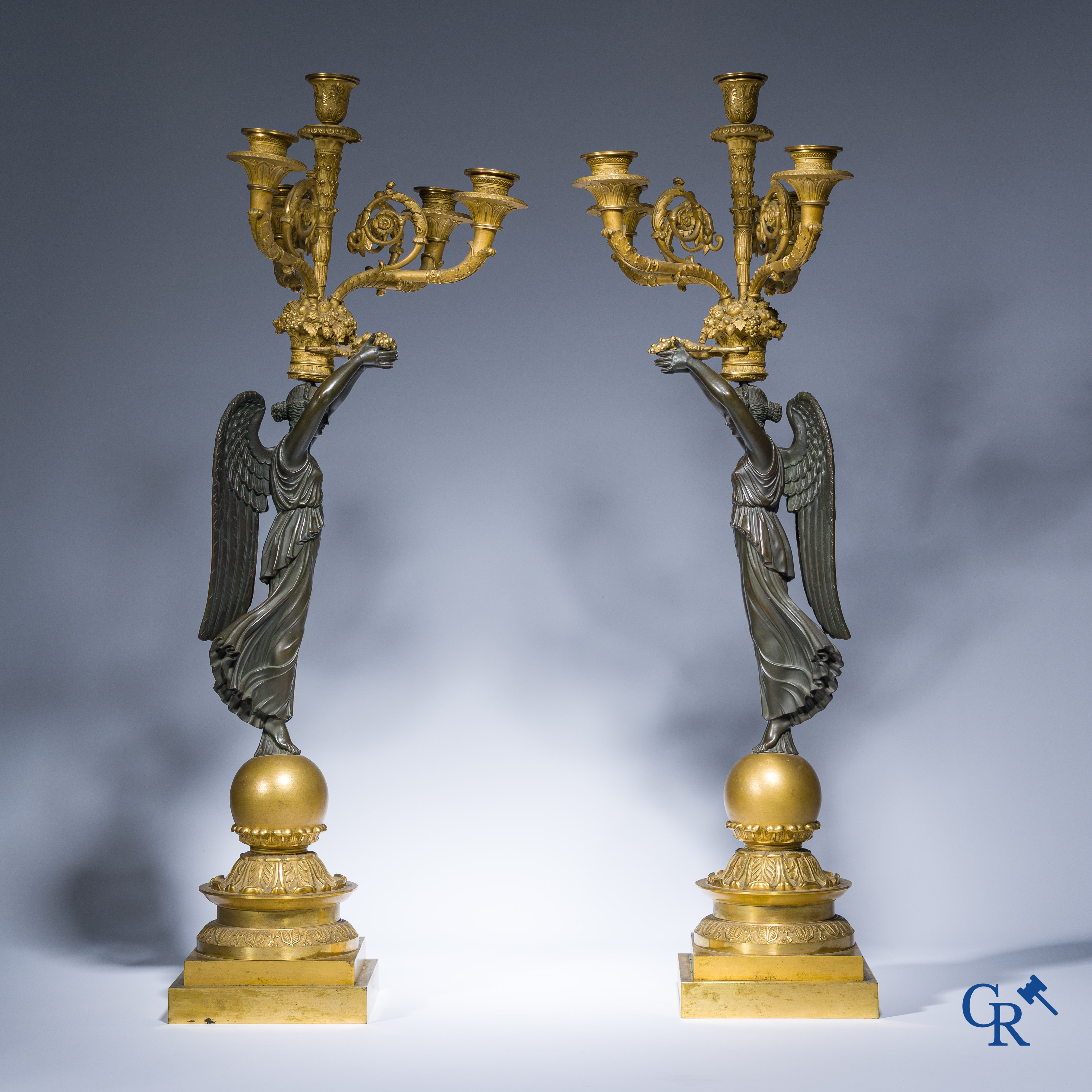 Empire, A pair of large gilded and patinated bronze candlesticks with winged women, circa 1810.