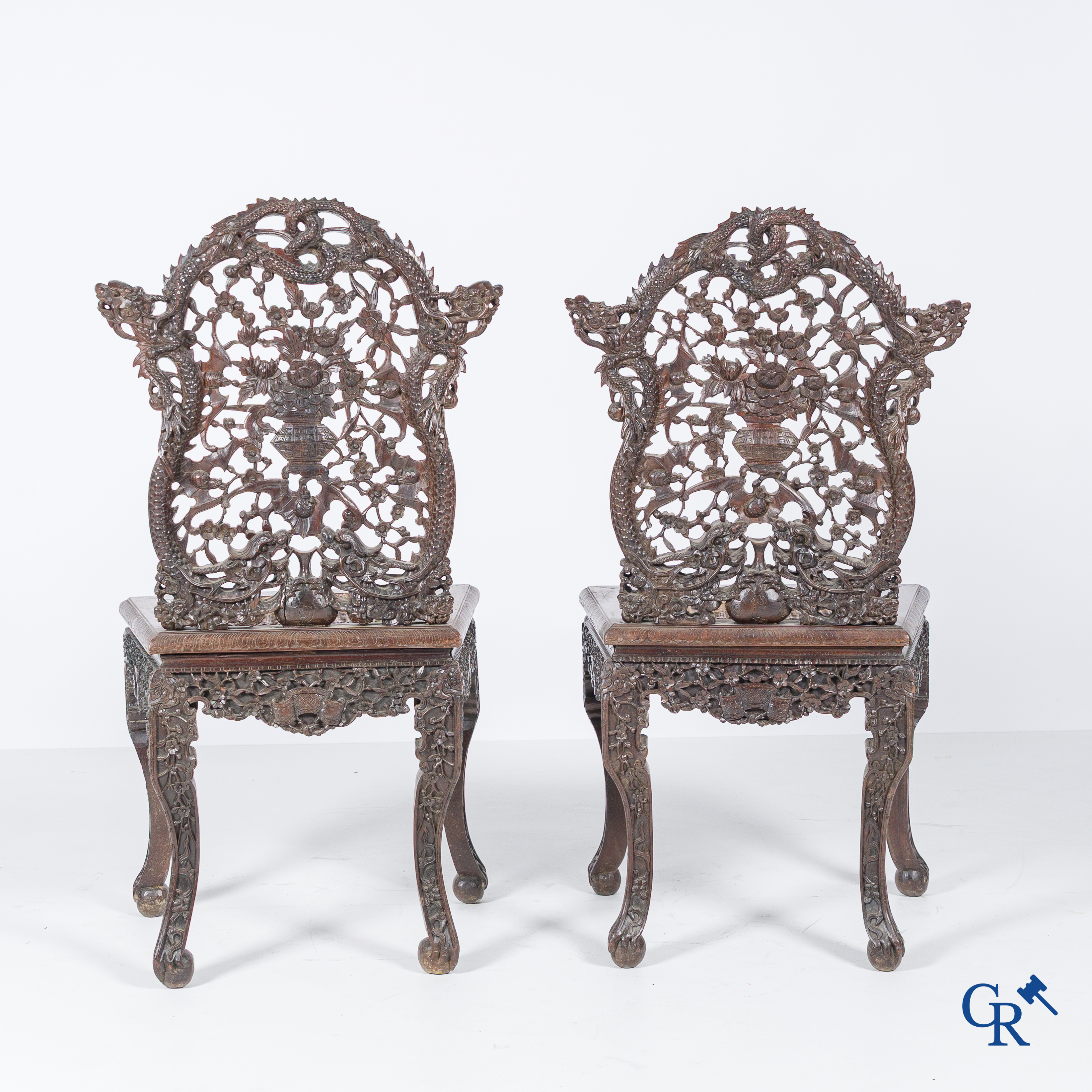 Asian Art, A pair of richly carved chairs with bats, dragons and flowers in Chinese hardwood. 19th century.