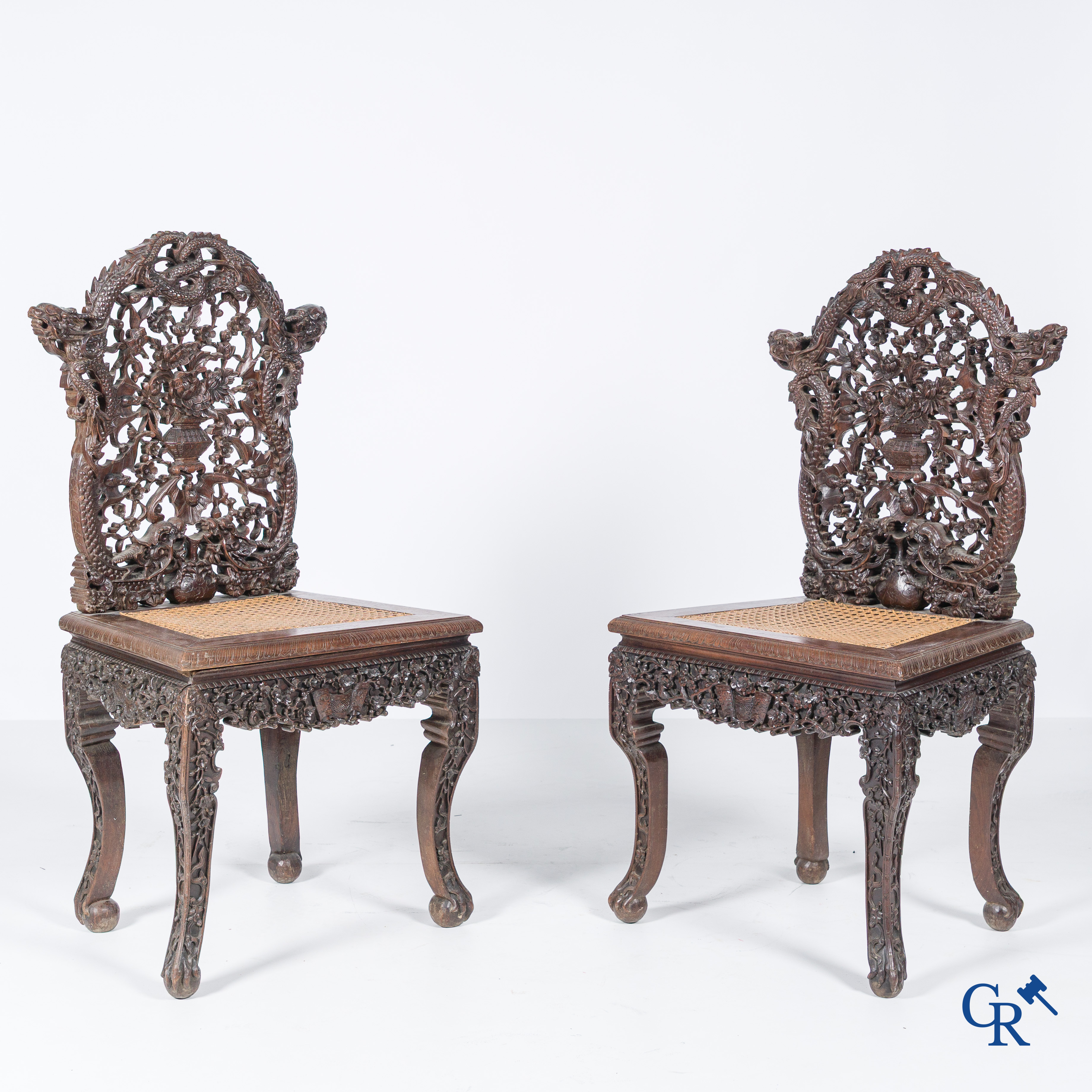 Asian Art, A pair of richly carved chairs with bats, dragons and flowers in Chinese hardwood. 19th century.