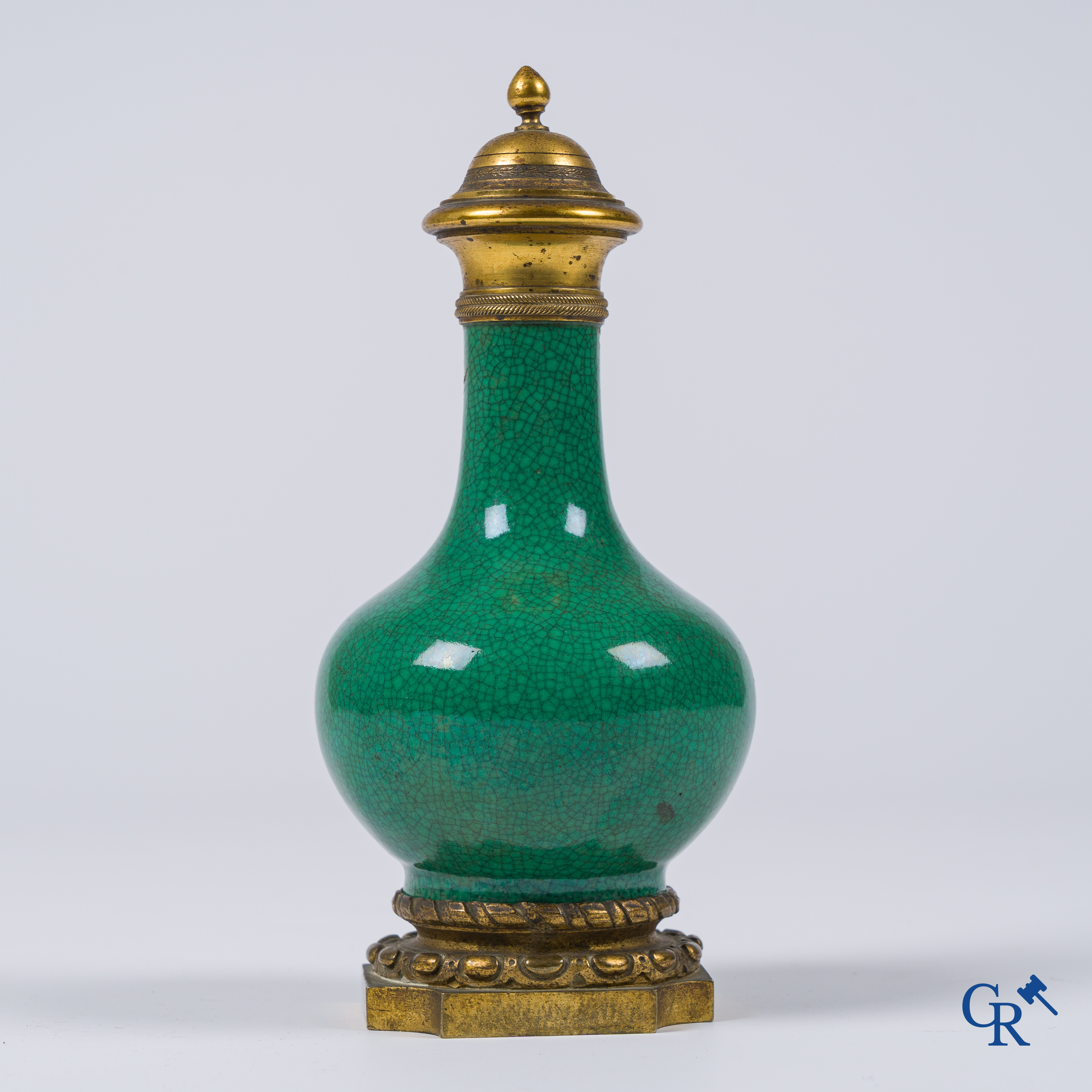 Asian Art. A porcelain vase in green crackle glaze with a bronze frame. 18th century.