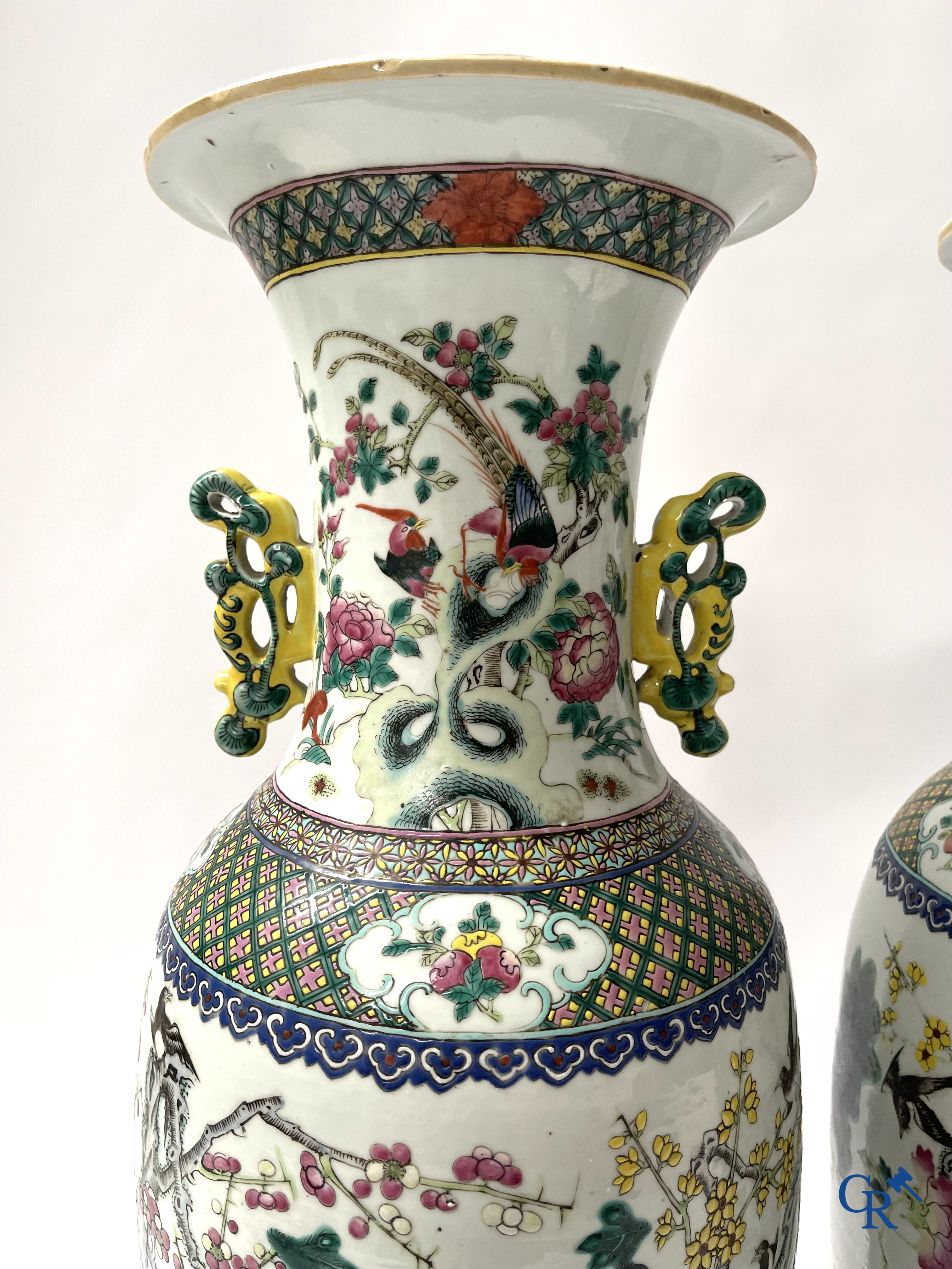 Asian Art, A pair of Chinese famille rose vases with peacocks and Fo dogs. 19th century.