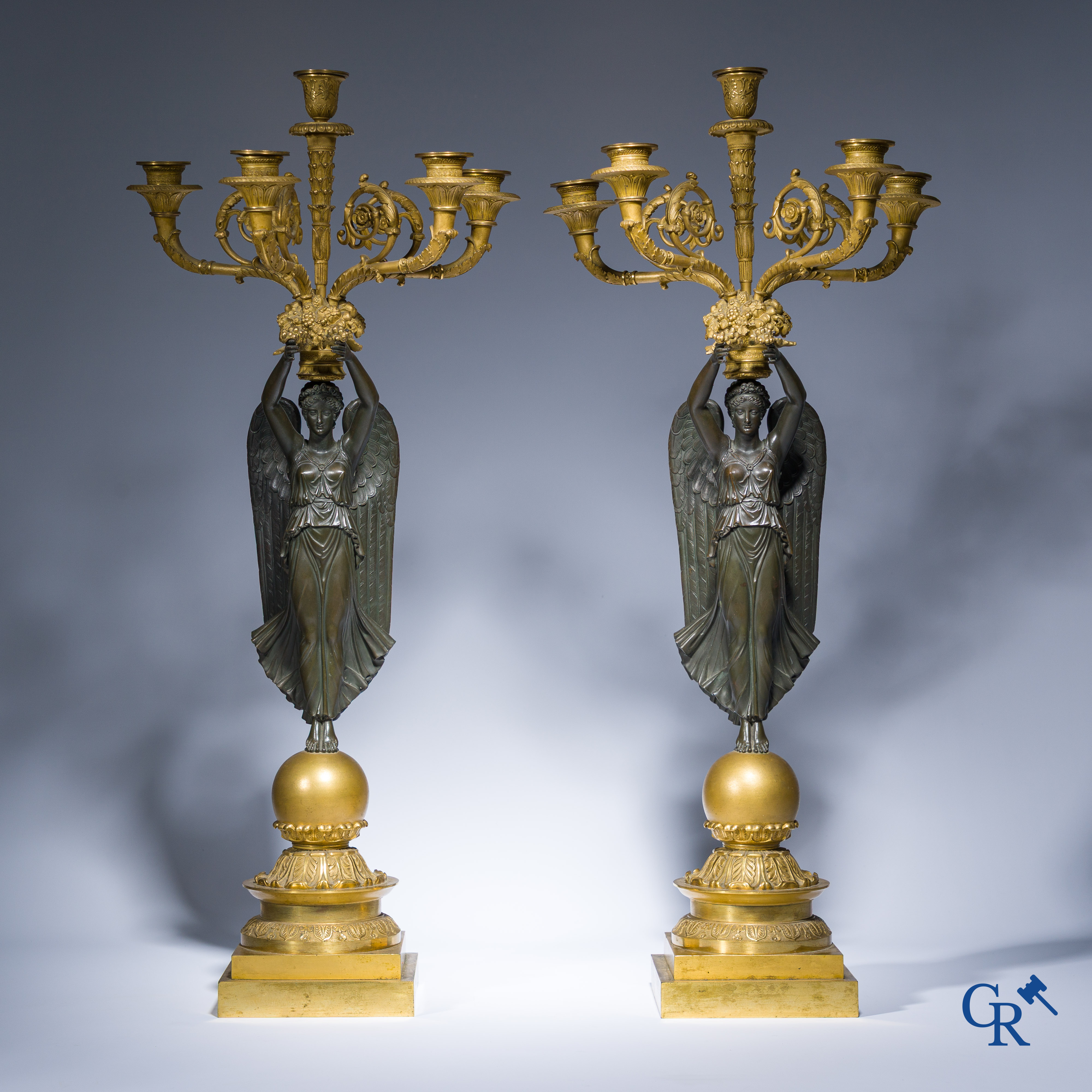 Empire, A pair of large gilded and patinated bronze candlesticks with winged women, circa 1810.