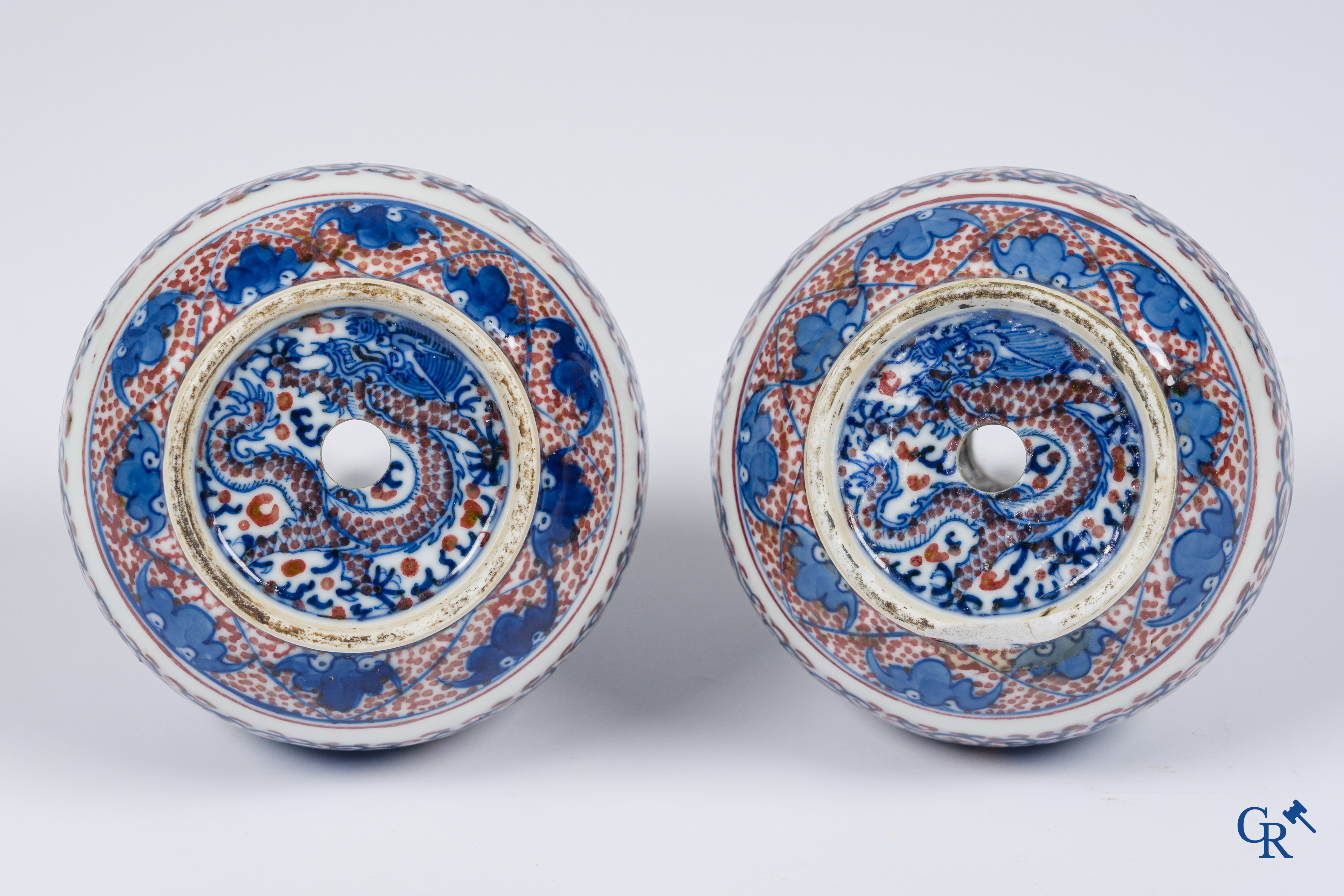 Asian Art, Chinese porcelain. A pair of blue-white and iron-red decorated vases with bats and a dragon bottom mark.