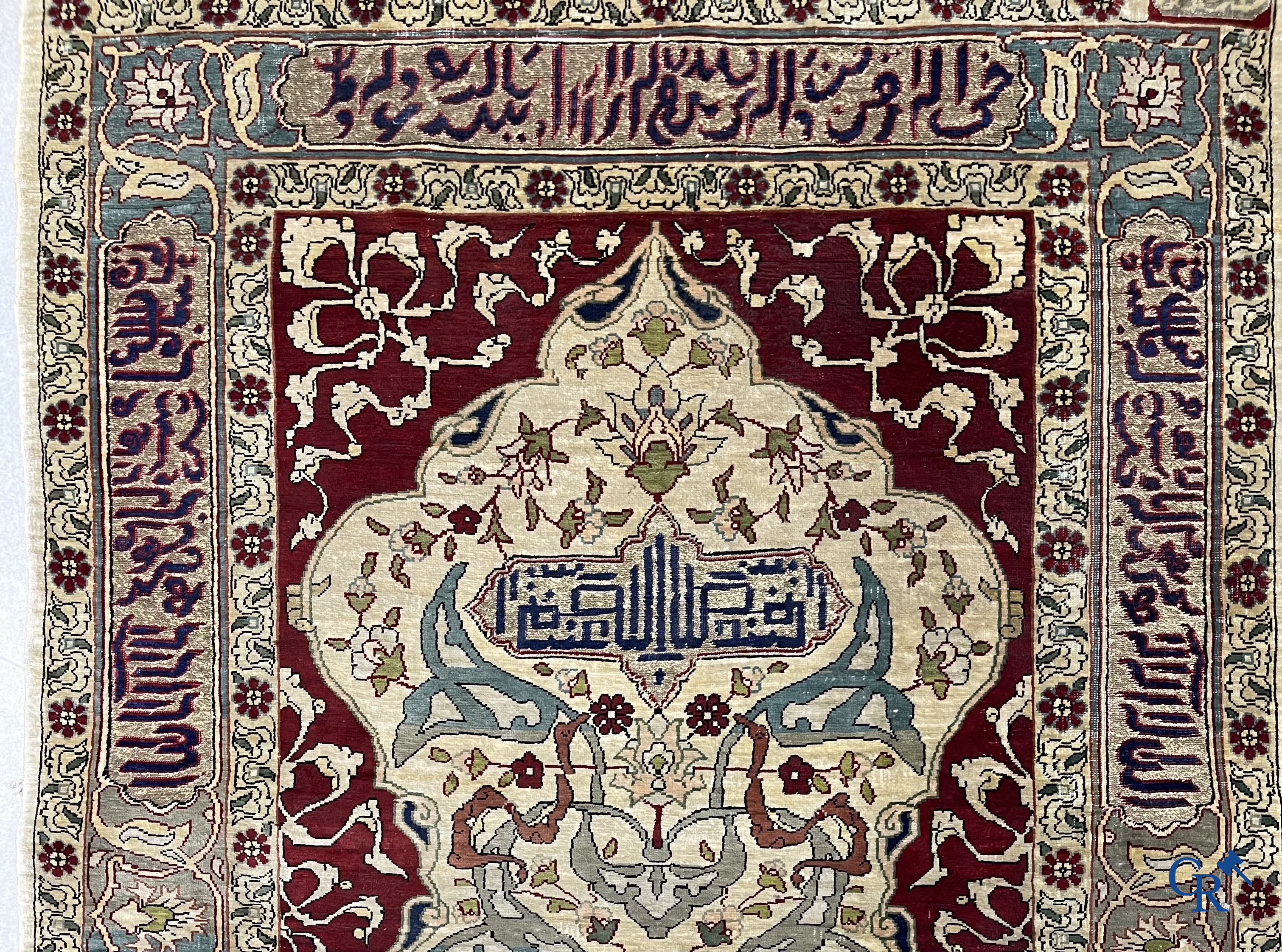 Oosterse tapijten. Een zijden gesigneerd tapijtje met inscripties en bewerkt met gouddraad.