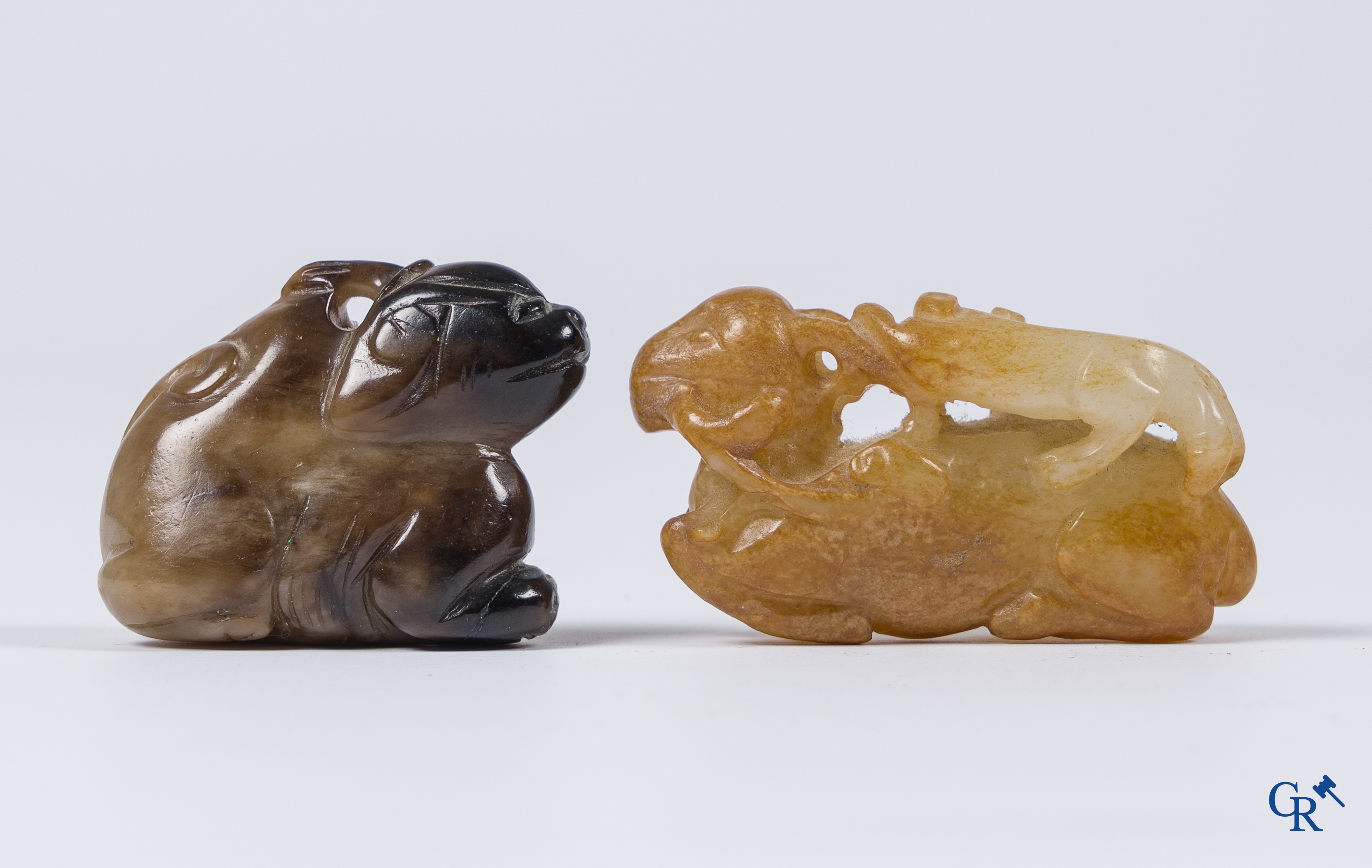 Aziatica. Een bleek celadon en roestbruin kleurige jade hertengroep en een bruinkleurig mythisch beest in jade.