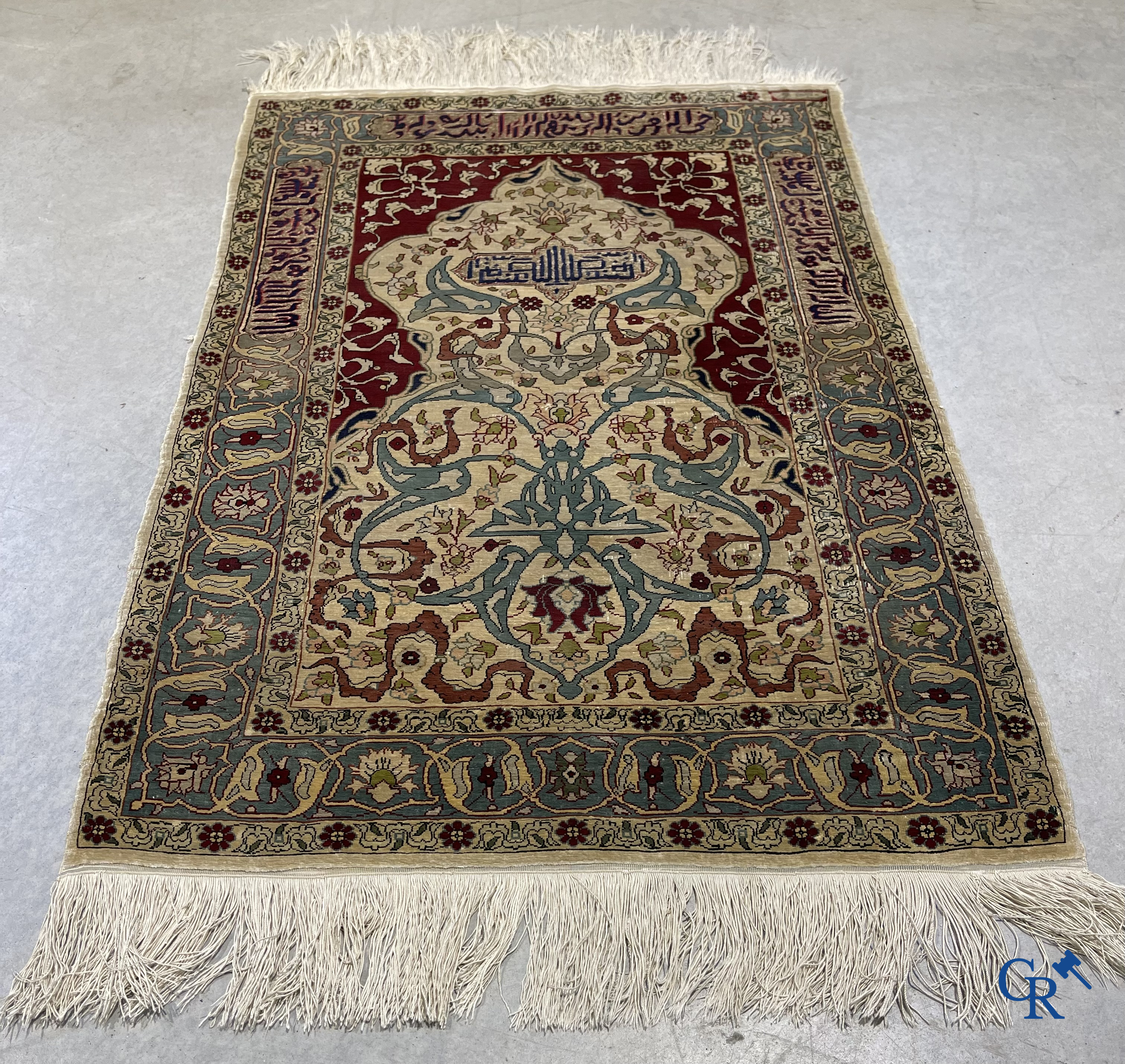 Oosterse tapijten. Een zijden gesigneerd tapijtje met inscripties en bewerkt met gouddraad.