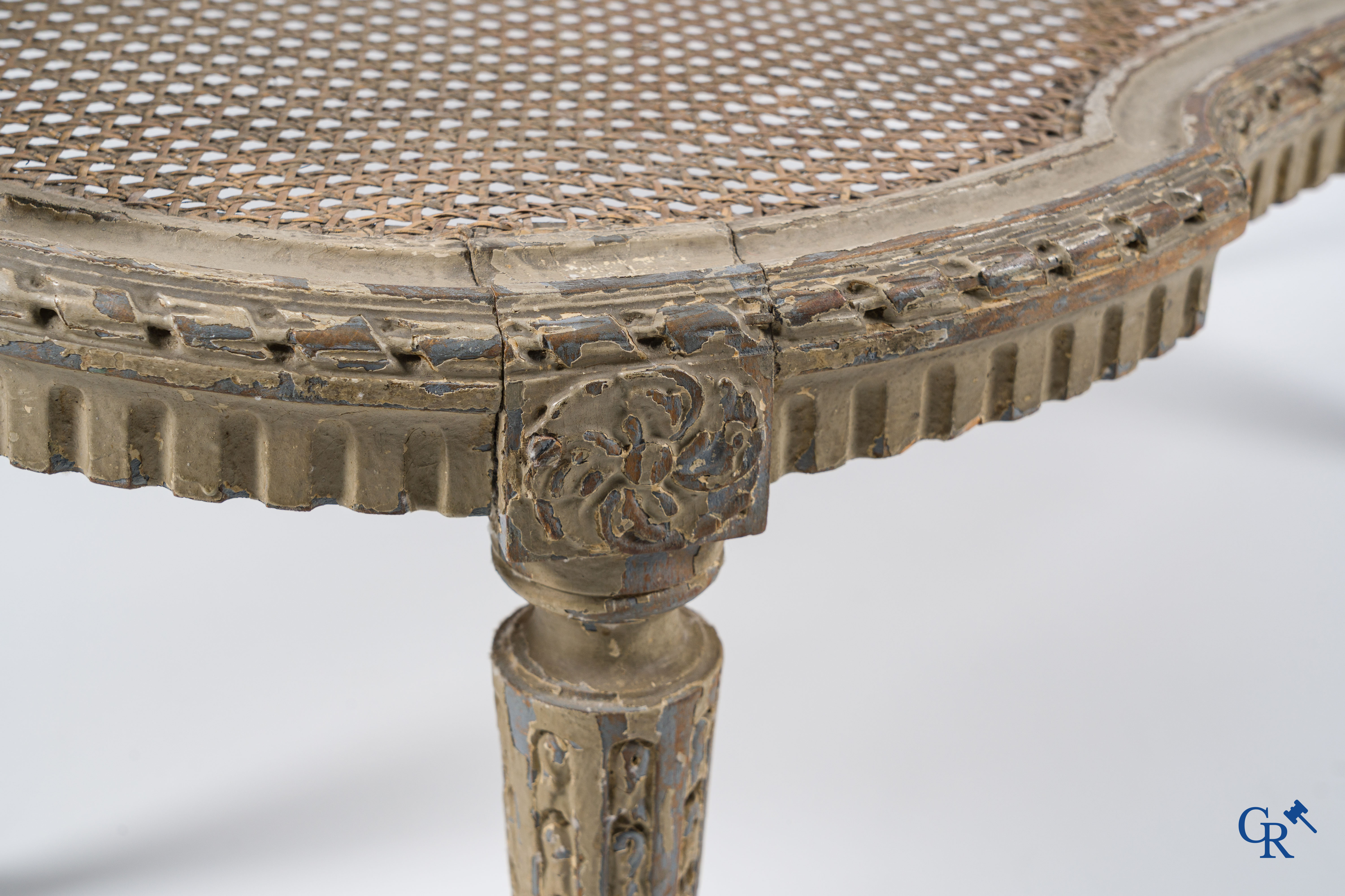 Epoque Louis XVI. Une banquette LXVI en bois sculpté à patine grise avec cannage. Fin du XVIIIème siècle.