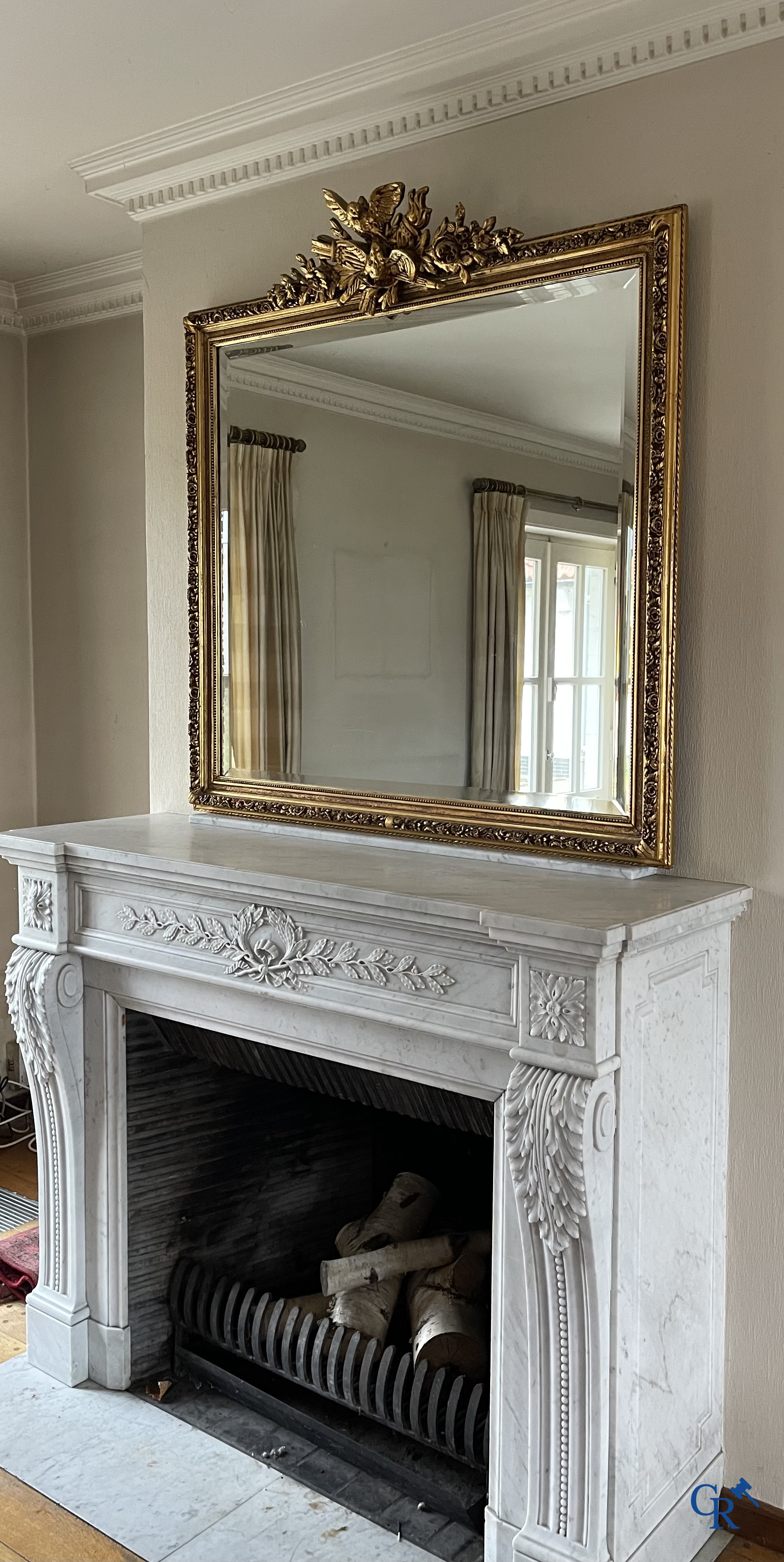A large gilded fireplace mirror in LXVI style. Circa 1920.