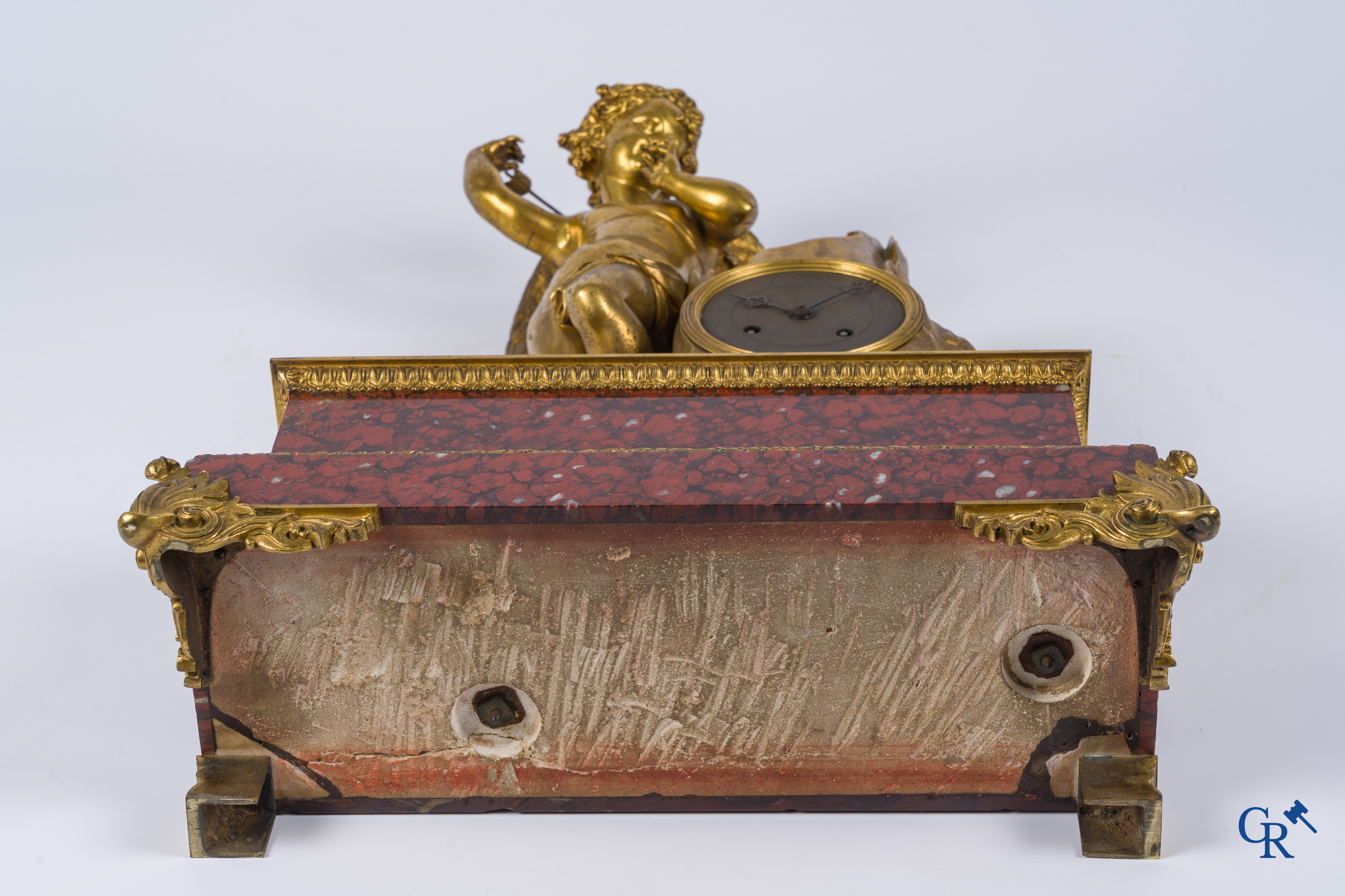 Charles X, pendule en bronze au cupidon finement ciselé et doré. Socle en marbre veiné rouge, vers 1840.