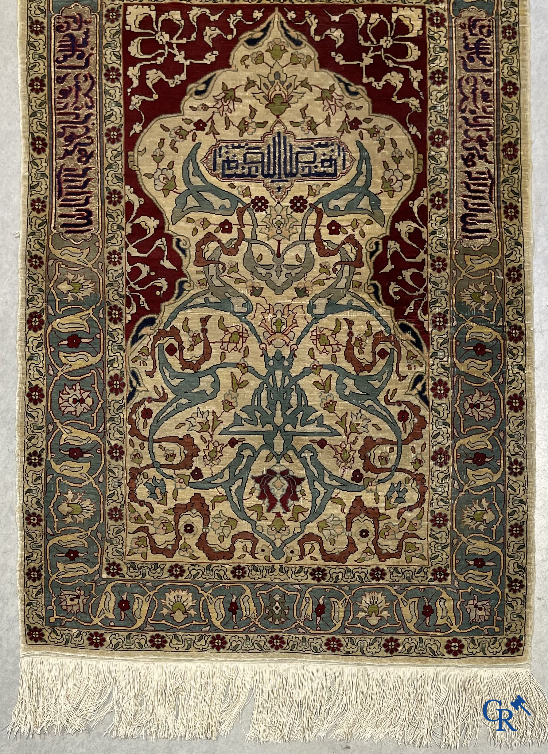 Oosterse tapijten. Een zijden gesigneerd tapijtje met inscripties en bewerkt met gouddraad.