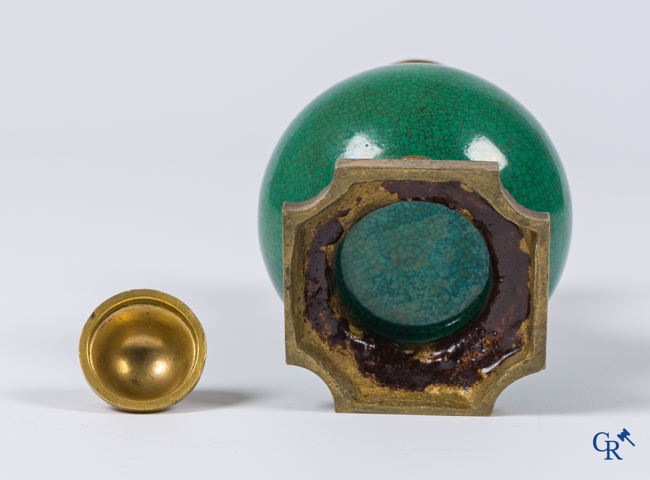 Asian Art. A porcelain vase in green crackle glaze with a bronze frame. 18th century.