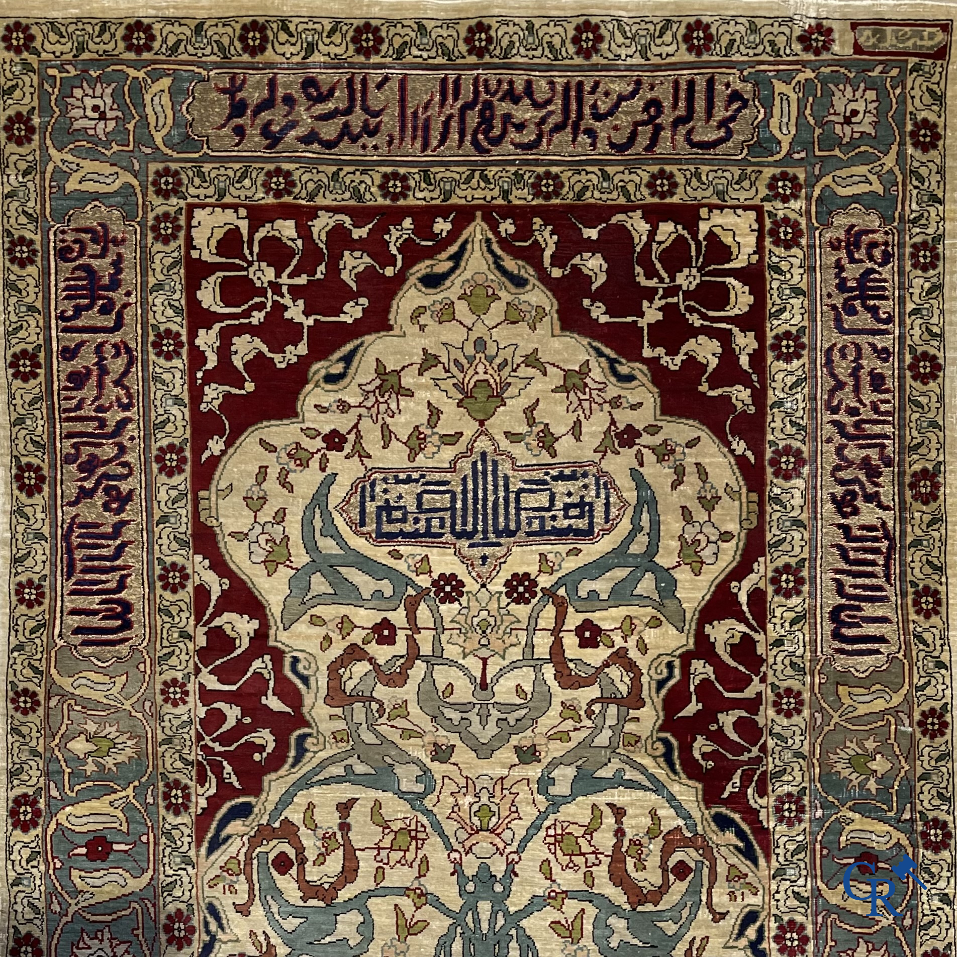 Oosterse tapijten. Een zijden gesigneerd tapijtje met inscripties en bewerkt met gouddraad.