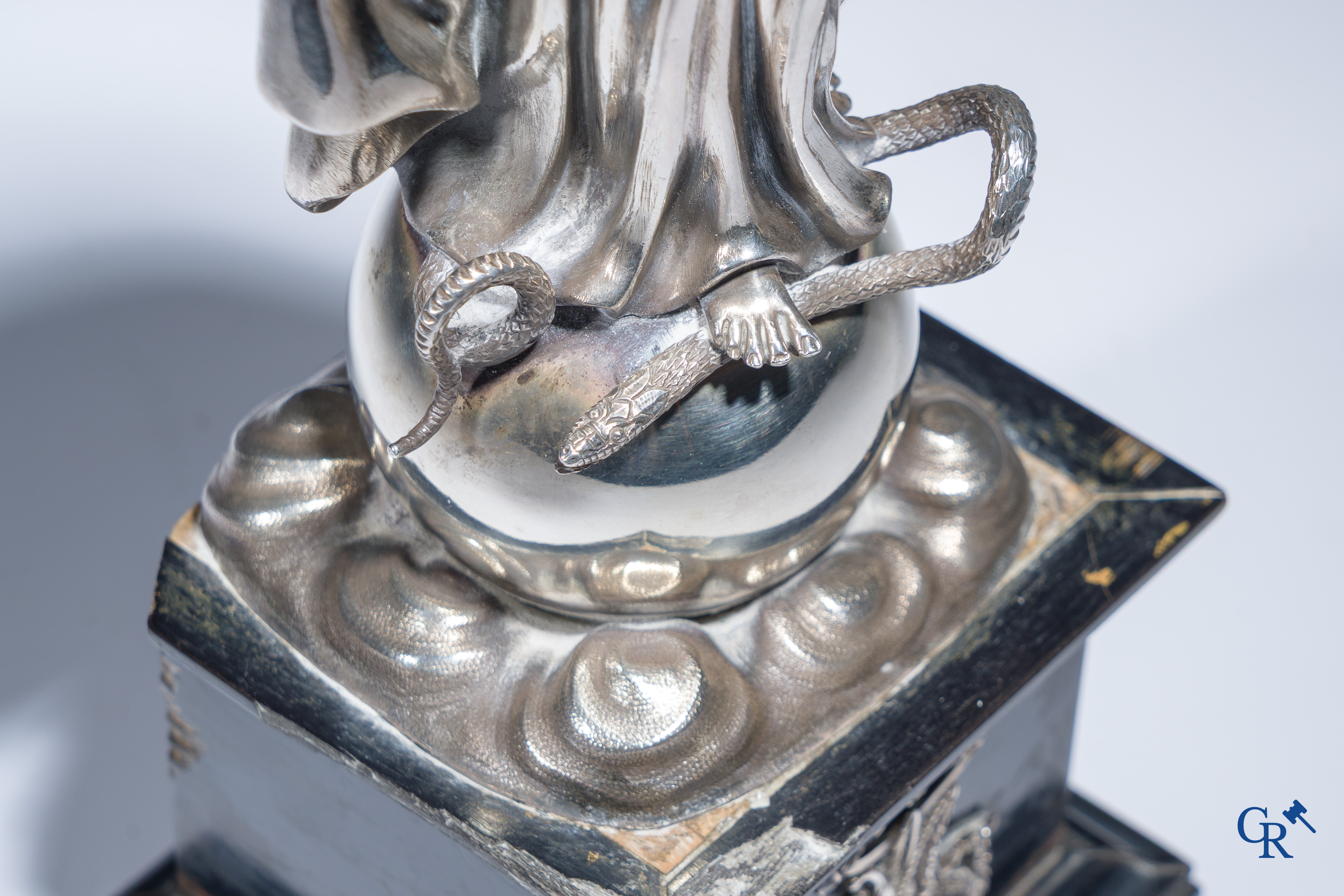 Een zilveren beeld van de Maagd Maria op een zwartgelakte sokkel in perelaar. Keurstempels Vieillard en Cérès.