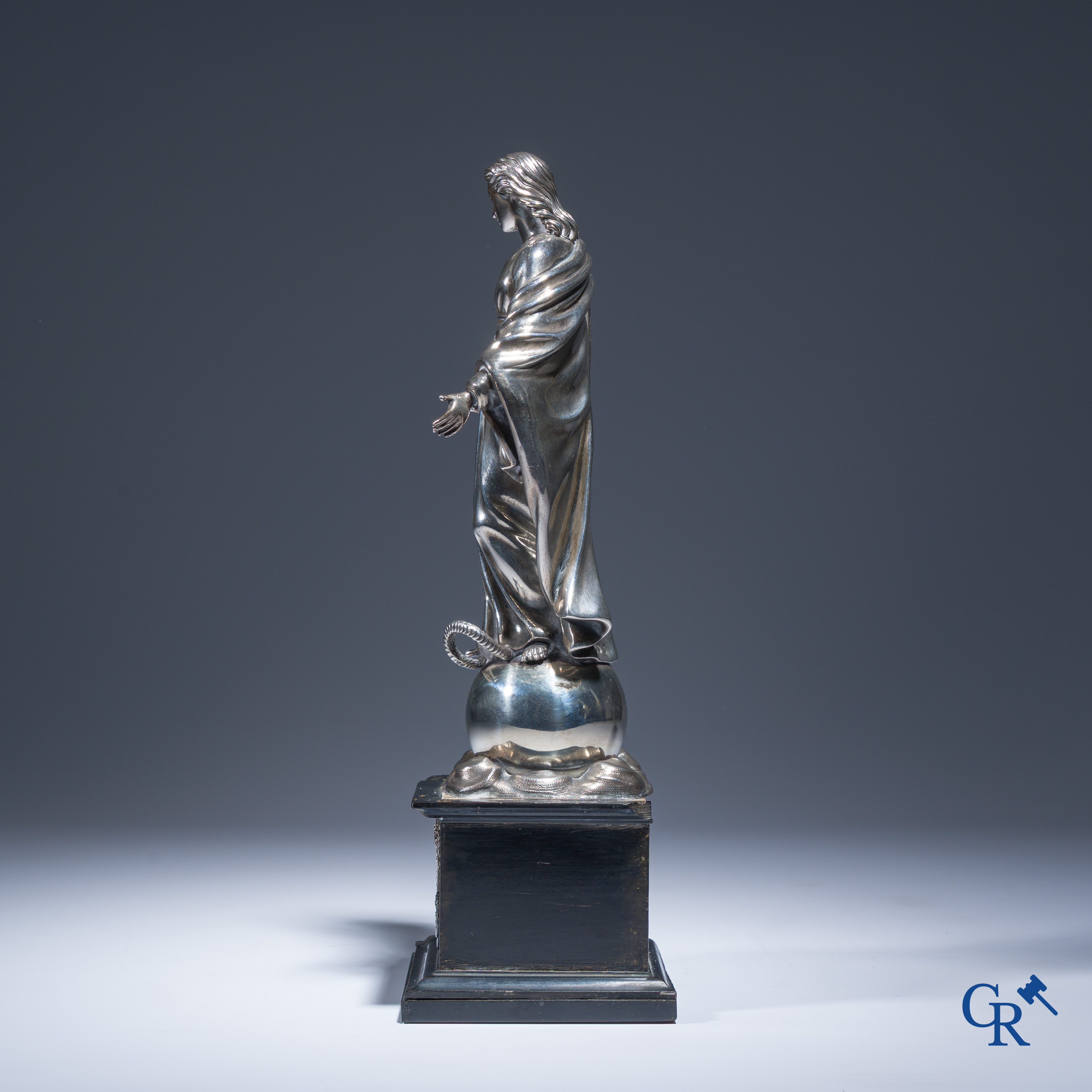 Een zilveren beeld van de Maagd Maria op een zwartgelakte sokkel in perelaar. Keurstempels Vieillard en Cérès.