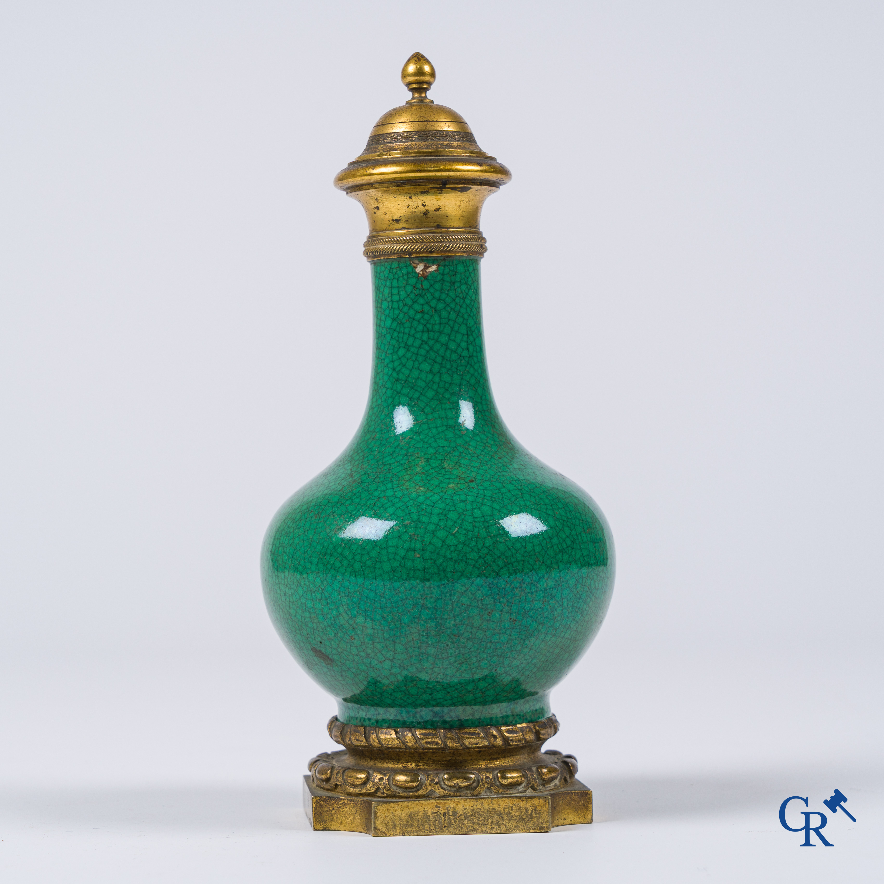 Asian Art. A porcelain vase in green crackle glaze with a bronze frame. 18th century.