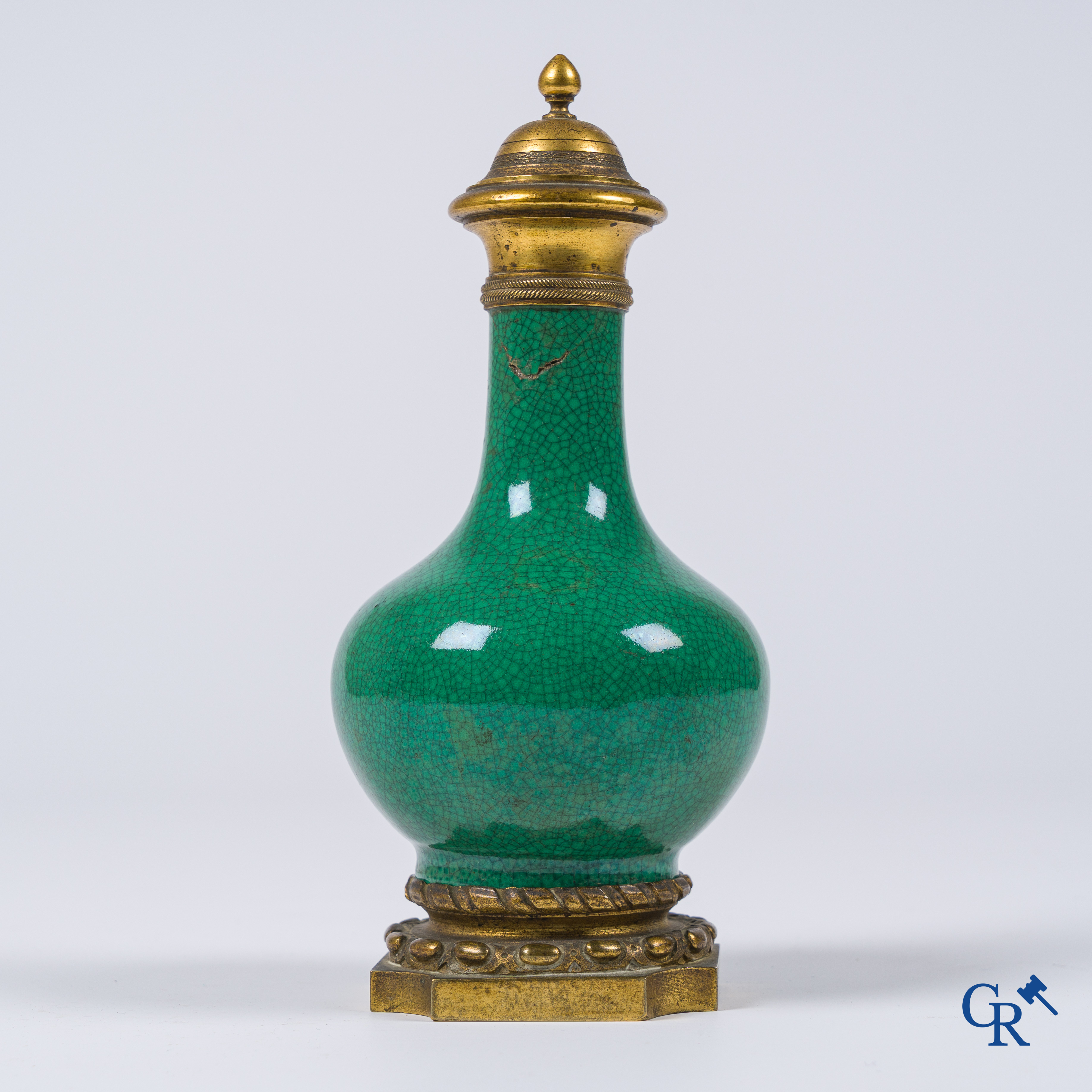 Asian Art. A porcelain vase in green crackle glaze with a bronze frame. 18th century.