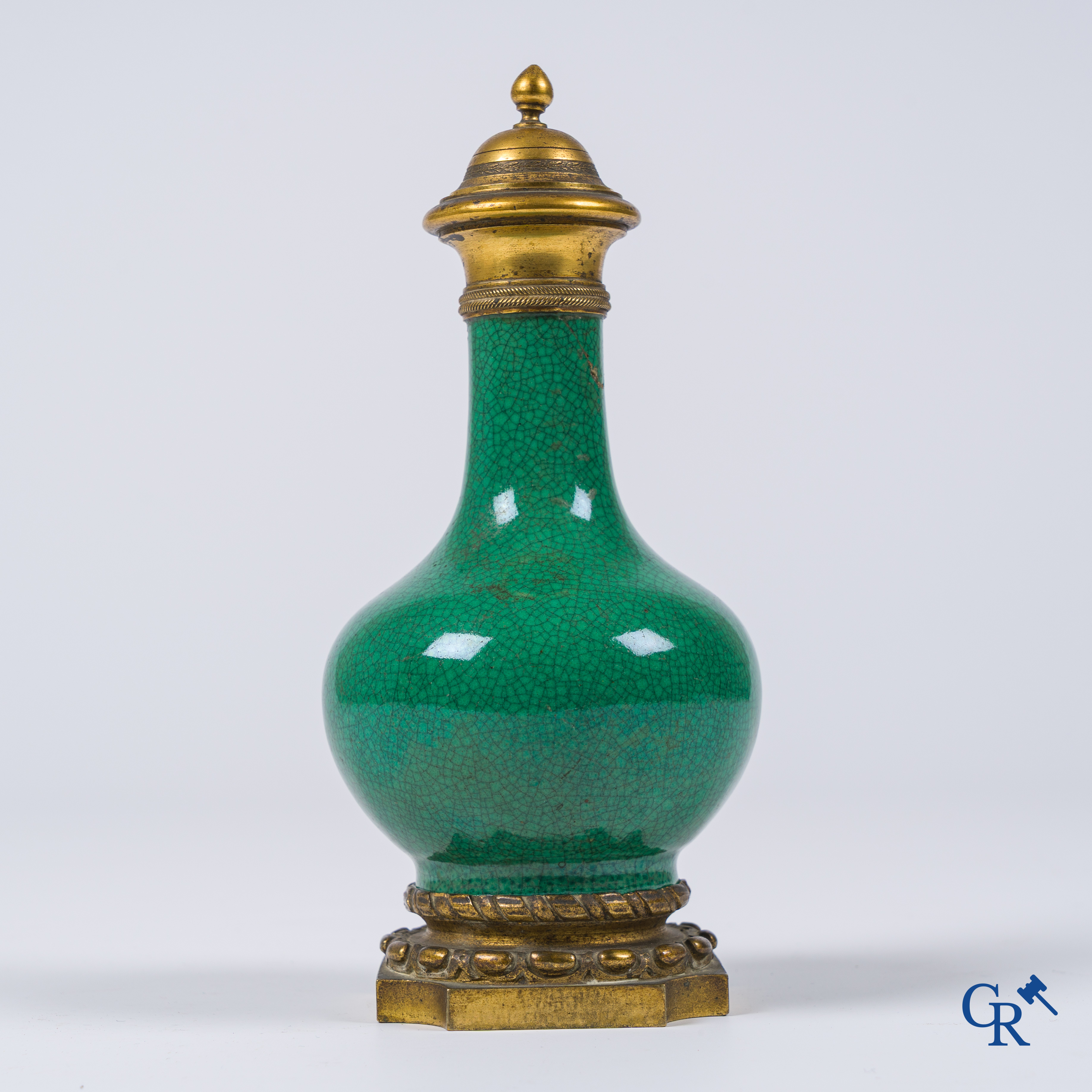 Asian Art. A porcelain vase in green crackle glaze with a bronze frame. 18th century.