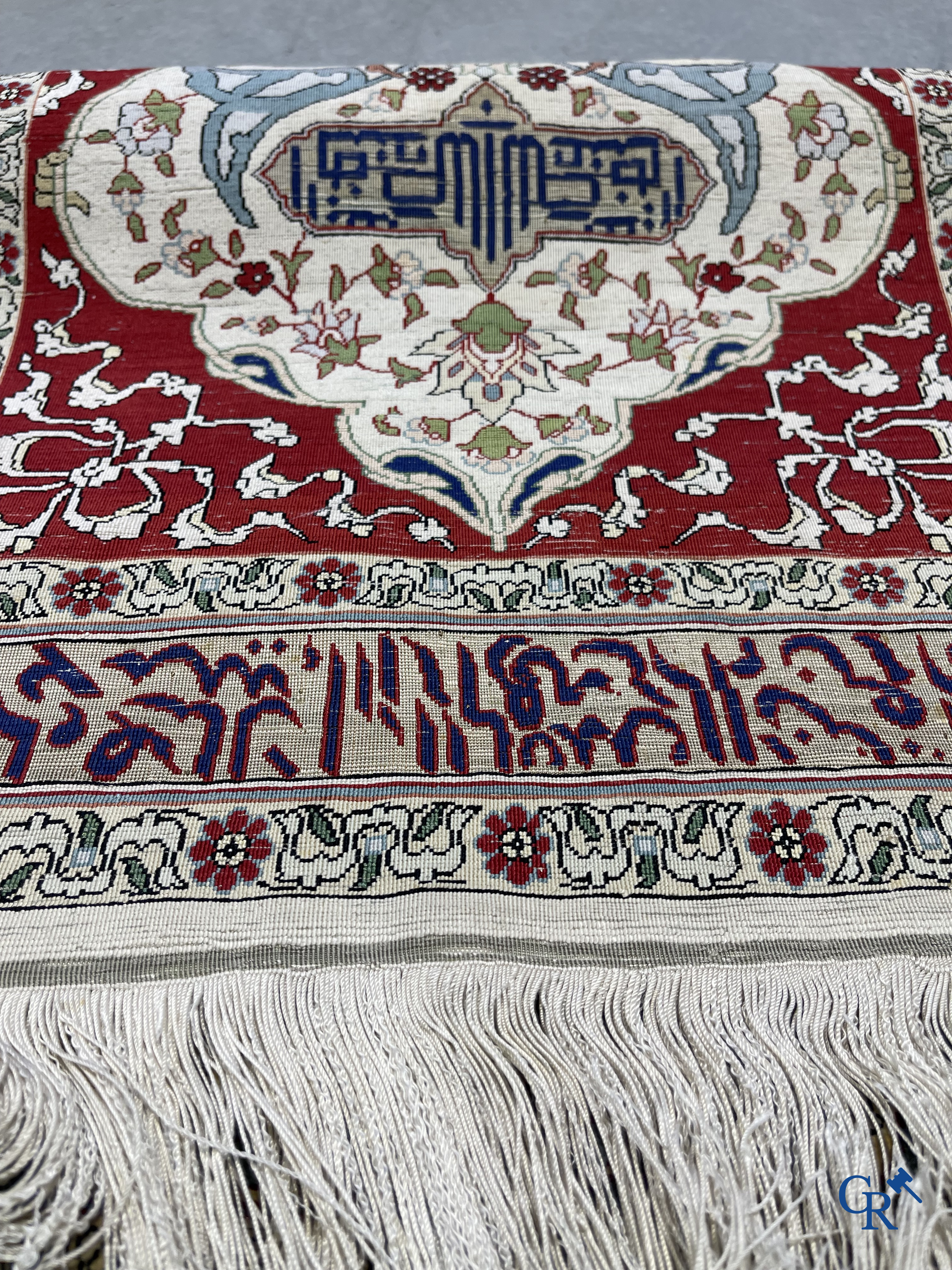 Oosterse tapijten. Een zijden gesigneerd tapijtje met inscripties en bewerkt met gouddraad.