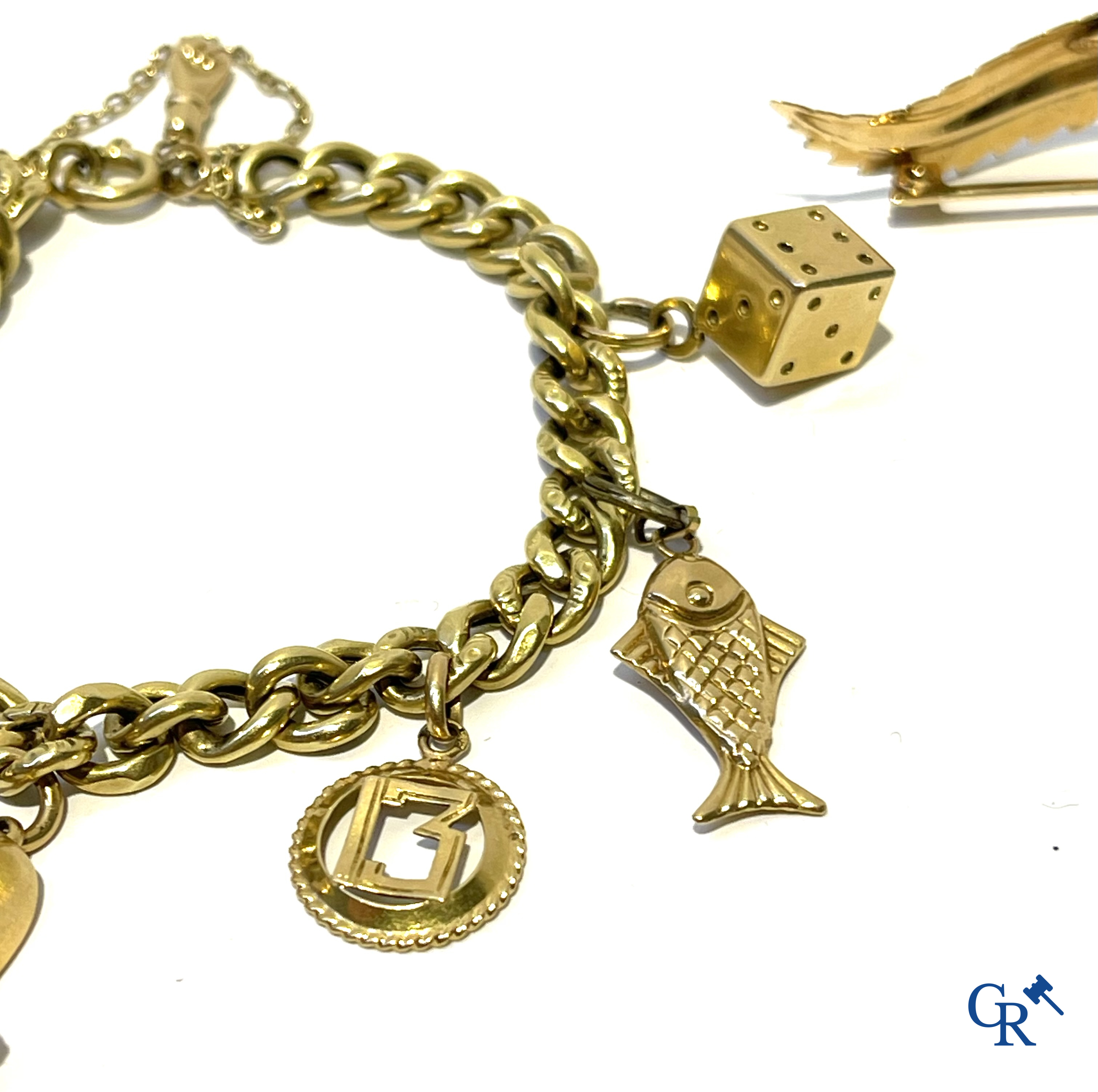 Juwelen, een bladvormige broche in goud 750°/00 en een bedelarmband in verschillende gehaltes goud.