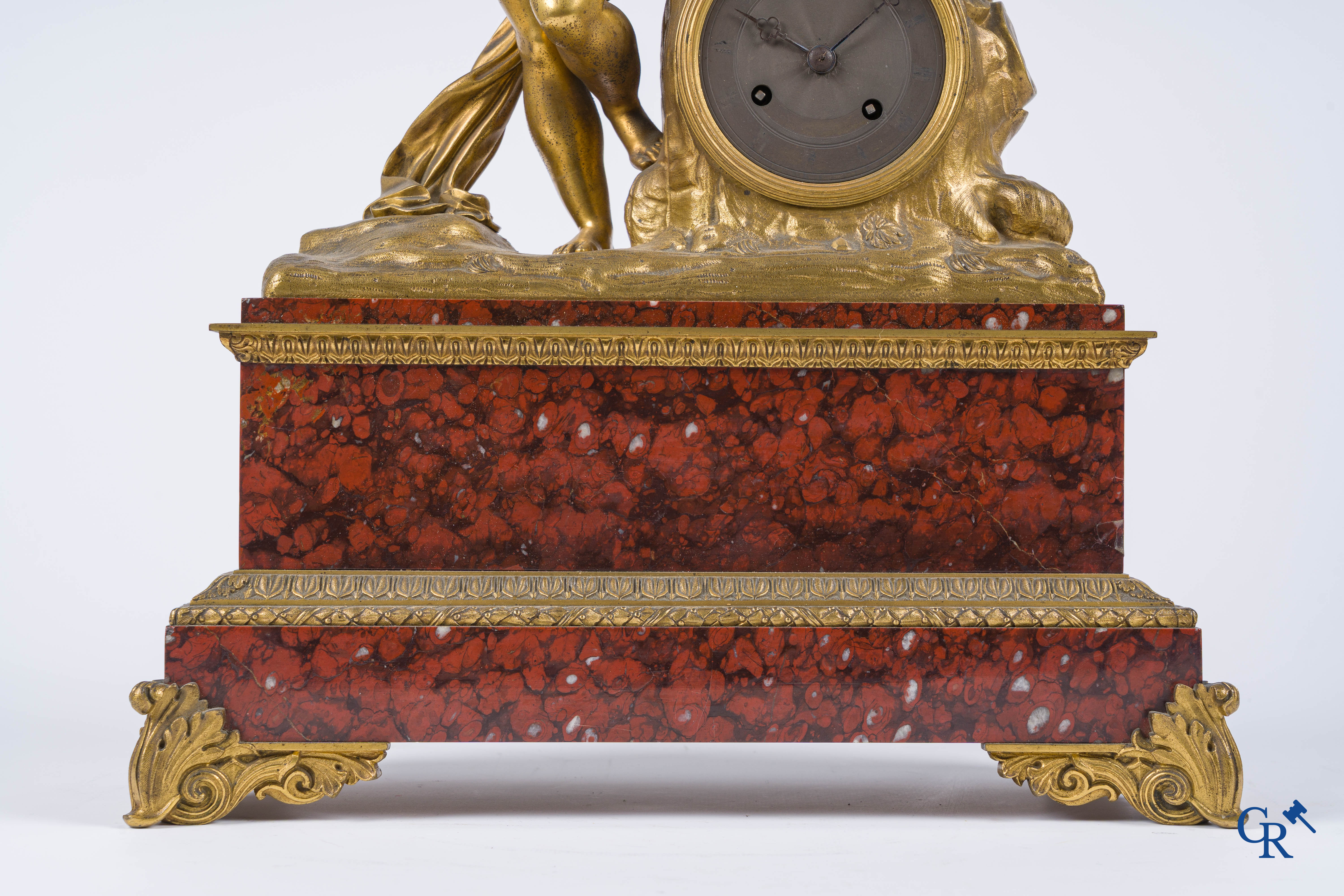 Charles X, pendule en bronze au cupidon finement ciselé et doré. Socle en marbre veiné rouge, vers 1840.