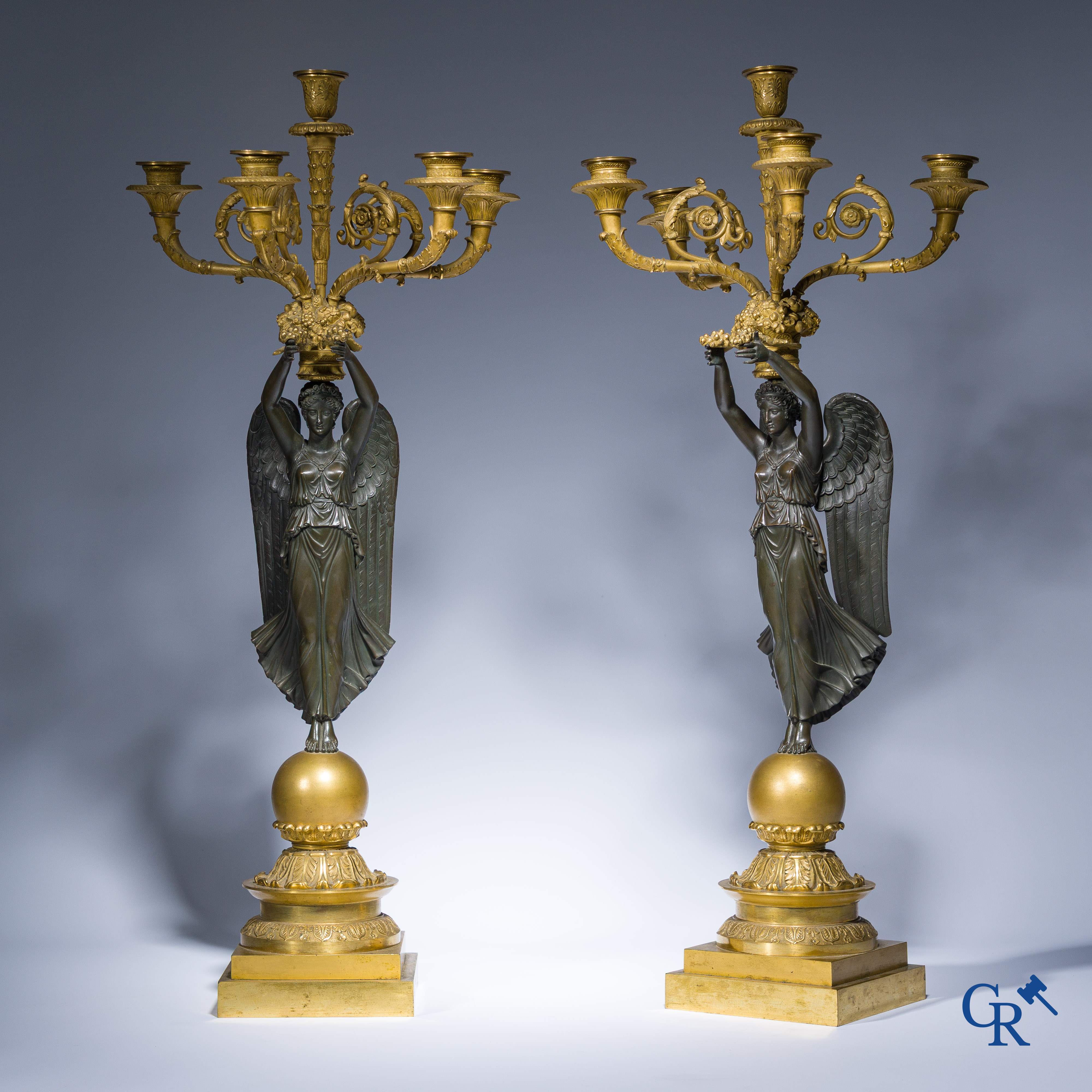 Empire, A pair of large gilded and patinated bronze candlesticks with winged women, circa 1810.