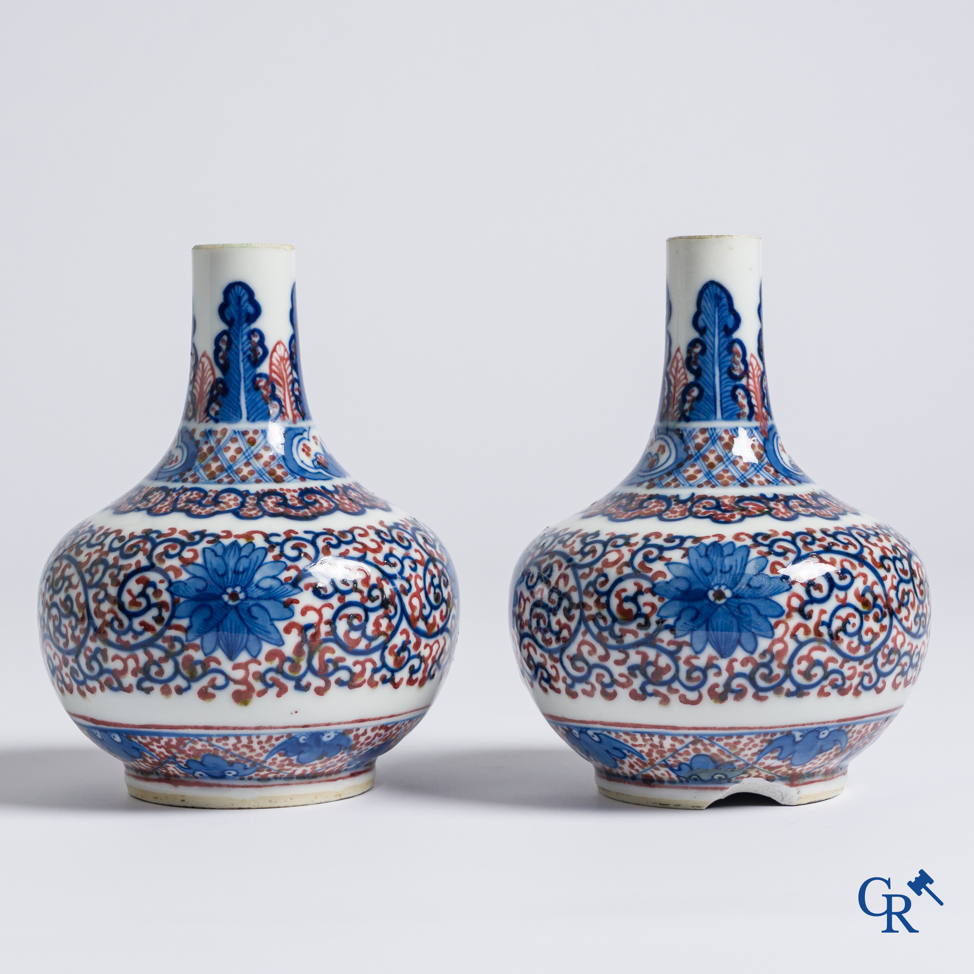 Asian Art, Chinese porcelain. A pair of blue-white and iron-red decorated vases with bats and a dragon bottom mark.