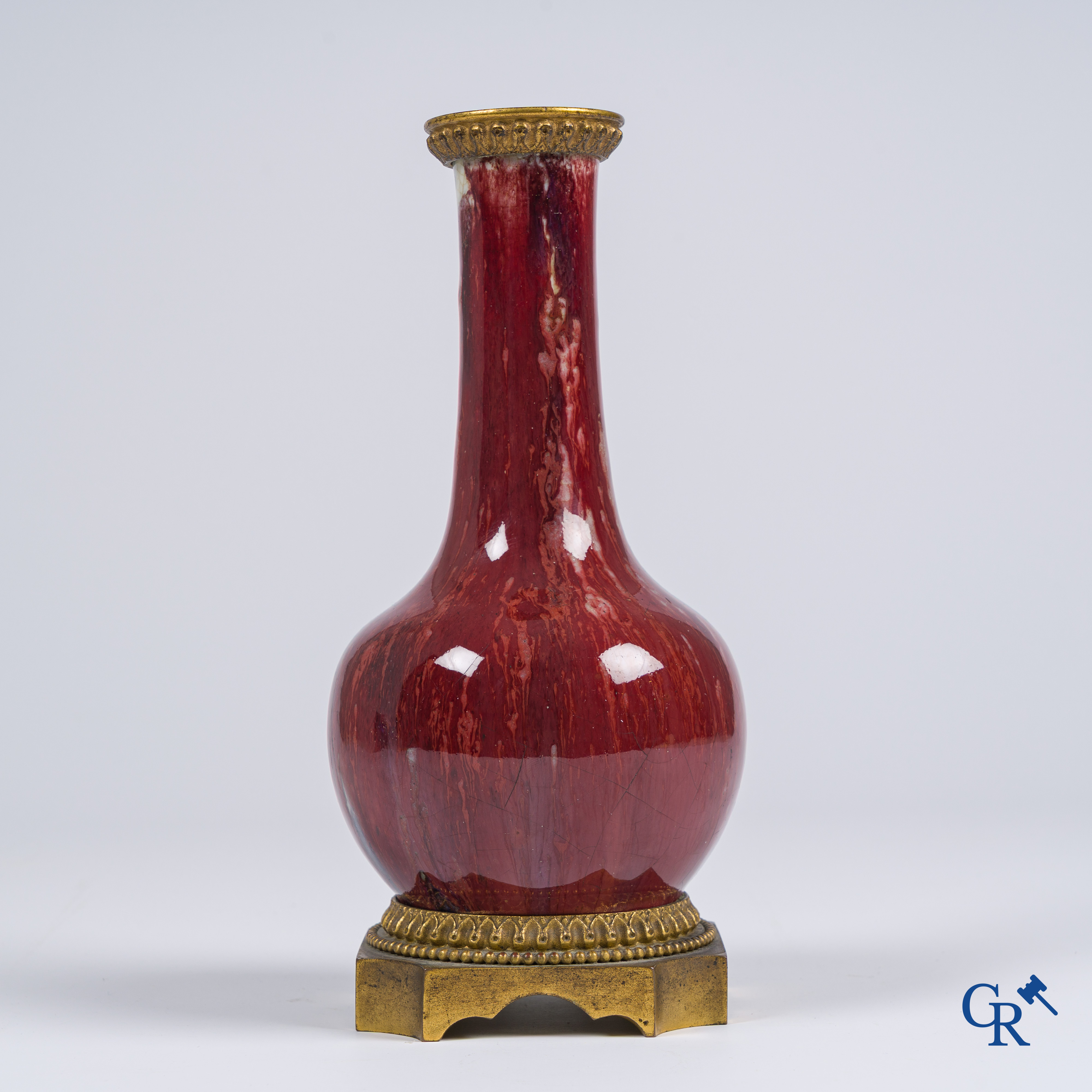 Asian Art, Chinese porcelain. A Chinese Sang de boeuf vase with gilded bronze. Marked.