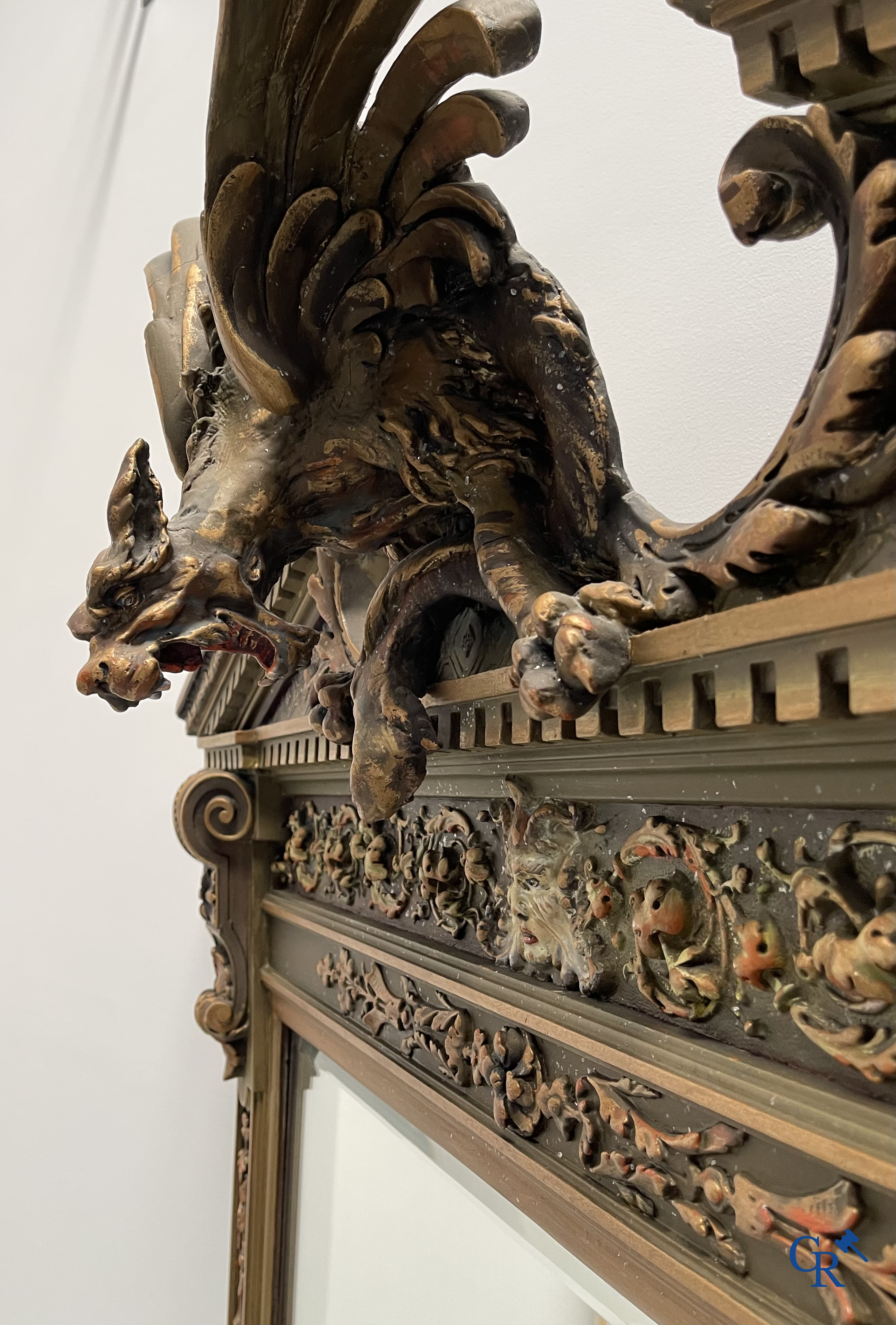 A large patinated fireplace mirror with a dragon. Around 1900.