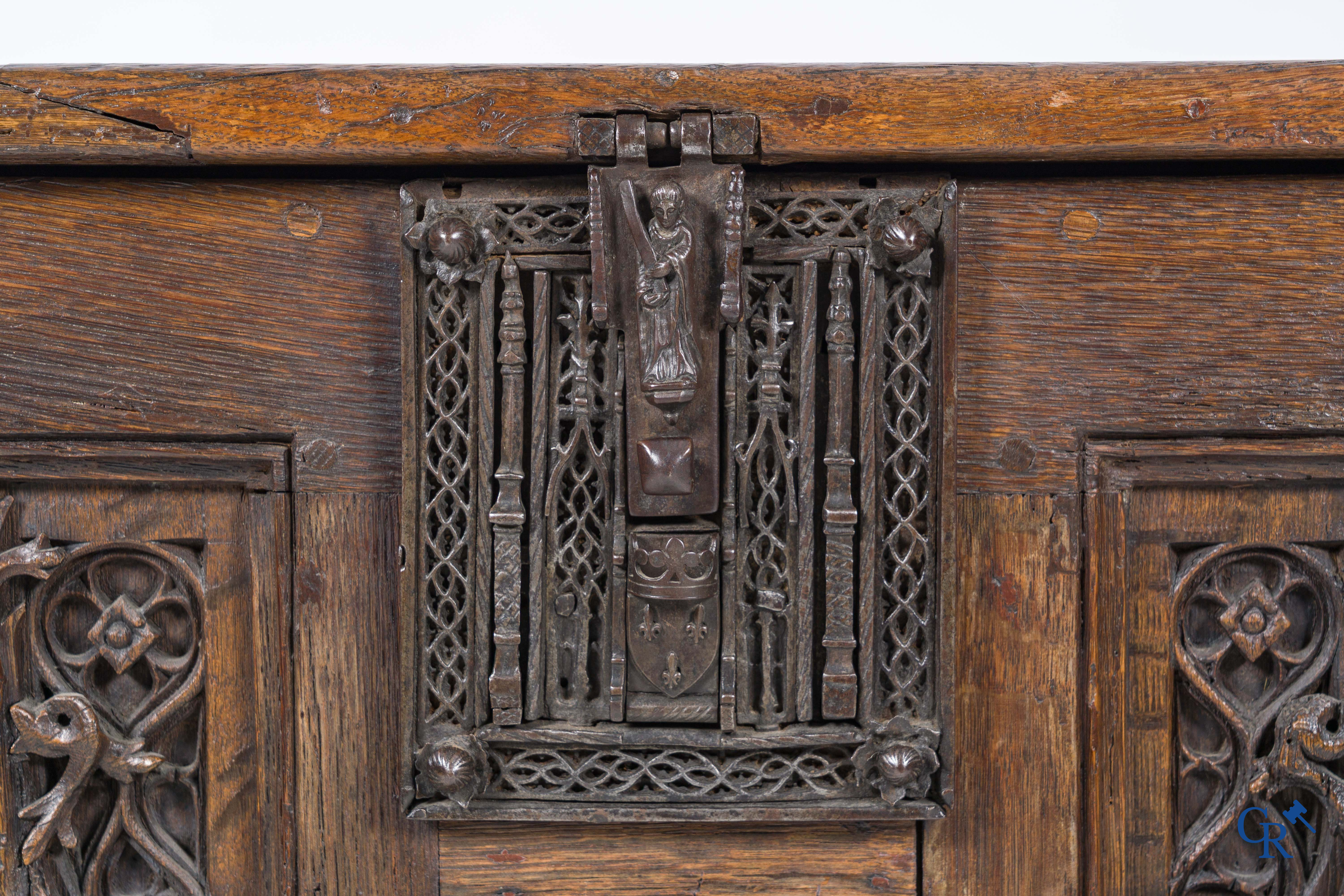 Gotiek. Een Gotische eikenhouten gesculpteerde koffer met zijn slotwerk in smeedijzer. 2de helft 15e eeuw.
