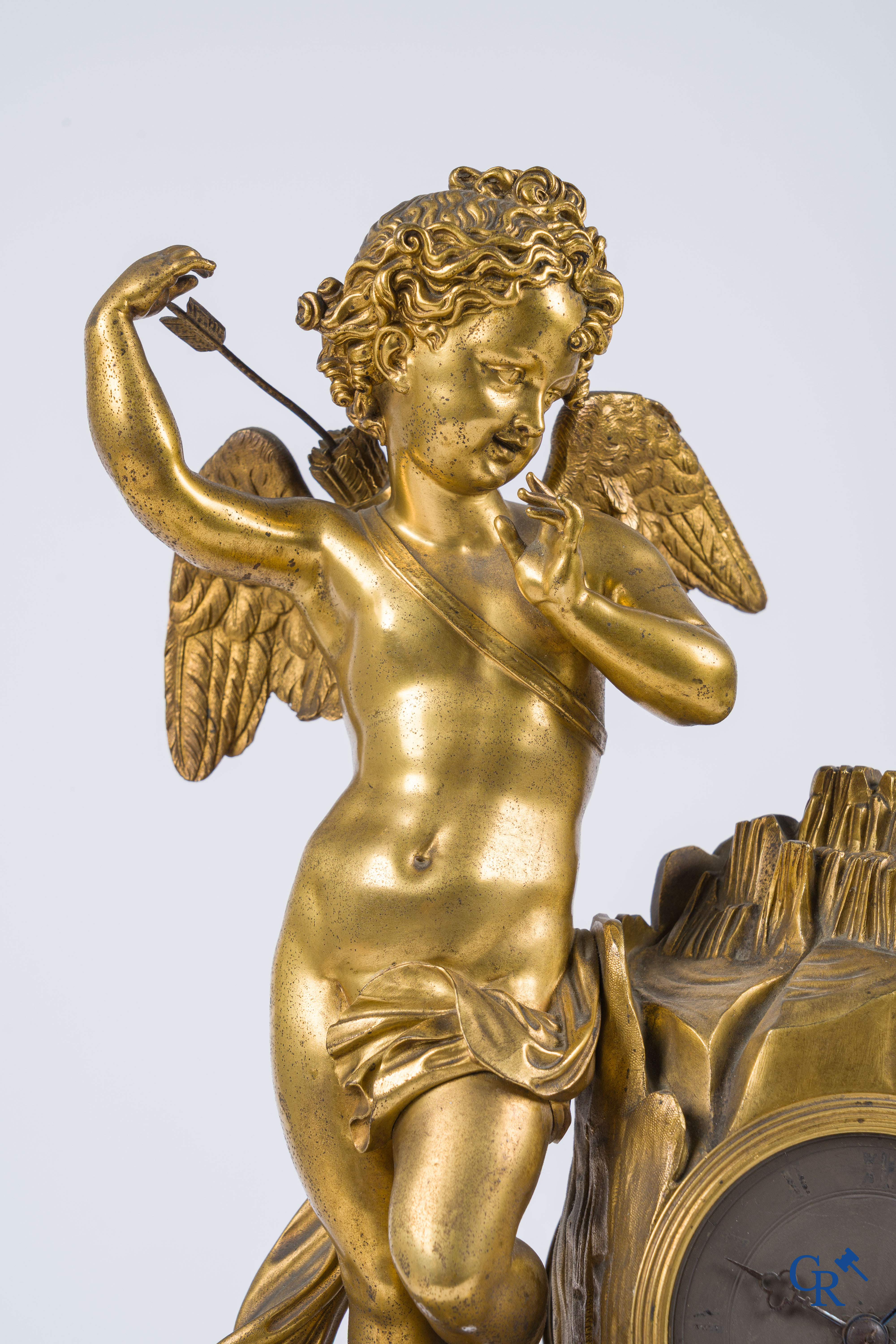 Charles X, pendule en bronze au cupidon finement ciselé et doré. Socle en marbre veiné rouge, vers 1840.
