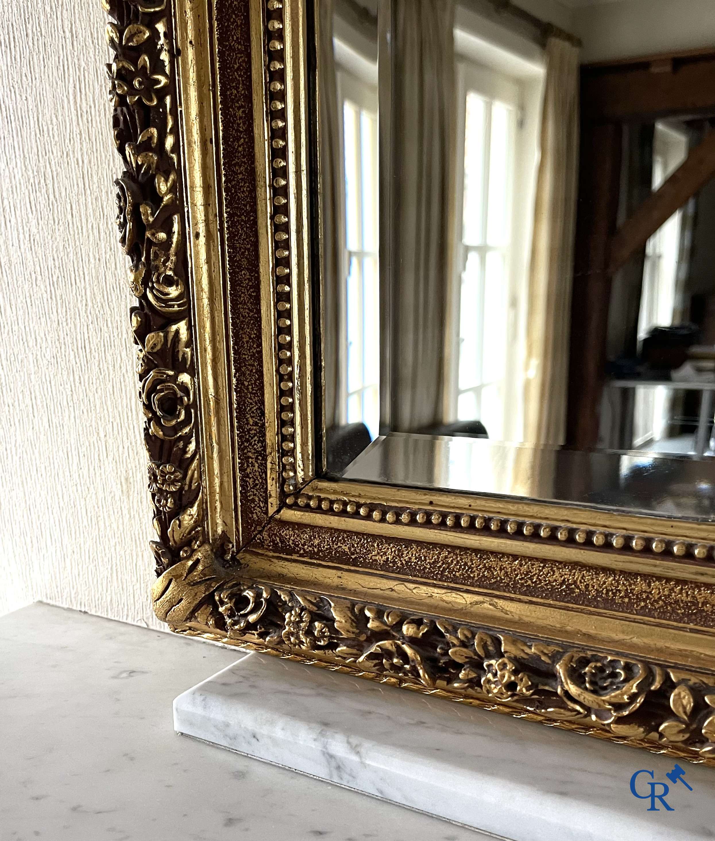 A large gilded fireplace mirror in LXVI style. Circa 1920.