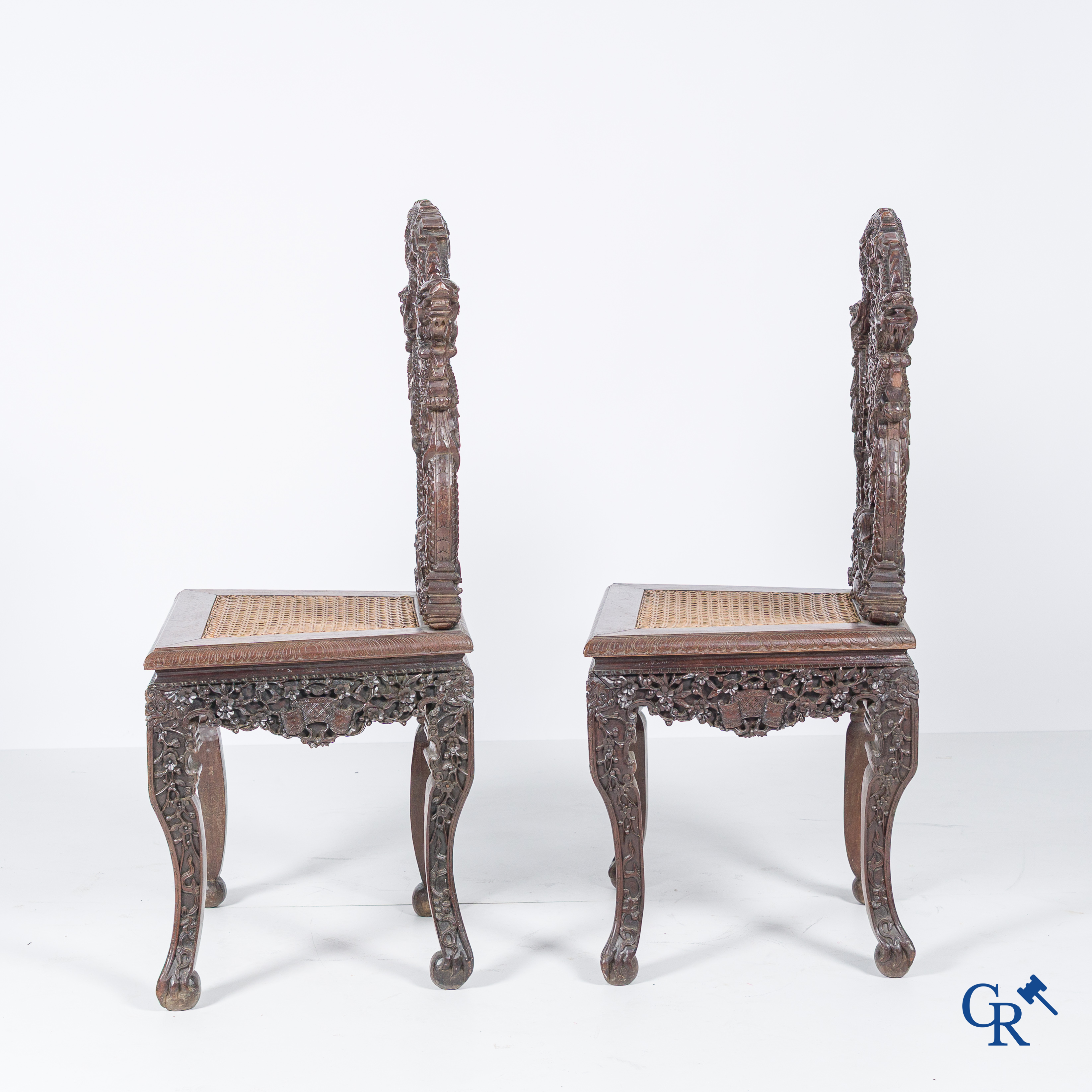 Asian Art, A pair of richly carved chairs with bats, dragons and flowers in Chinese hardwood. 19th century.