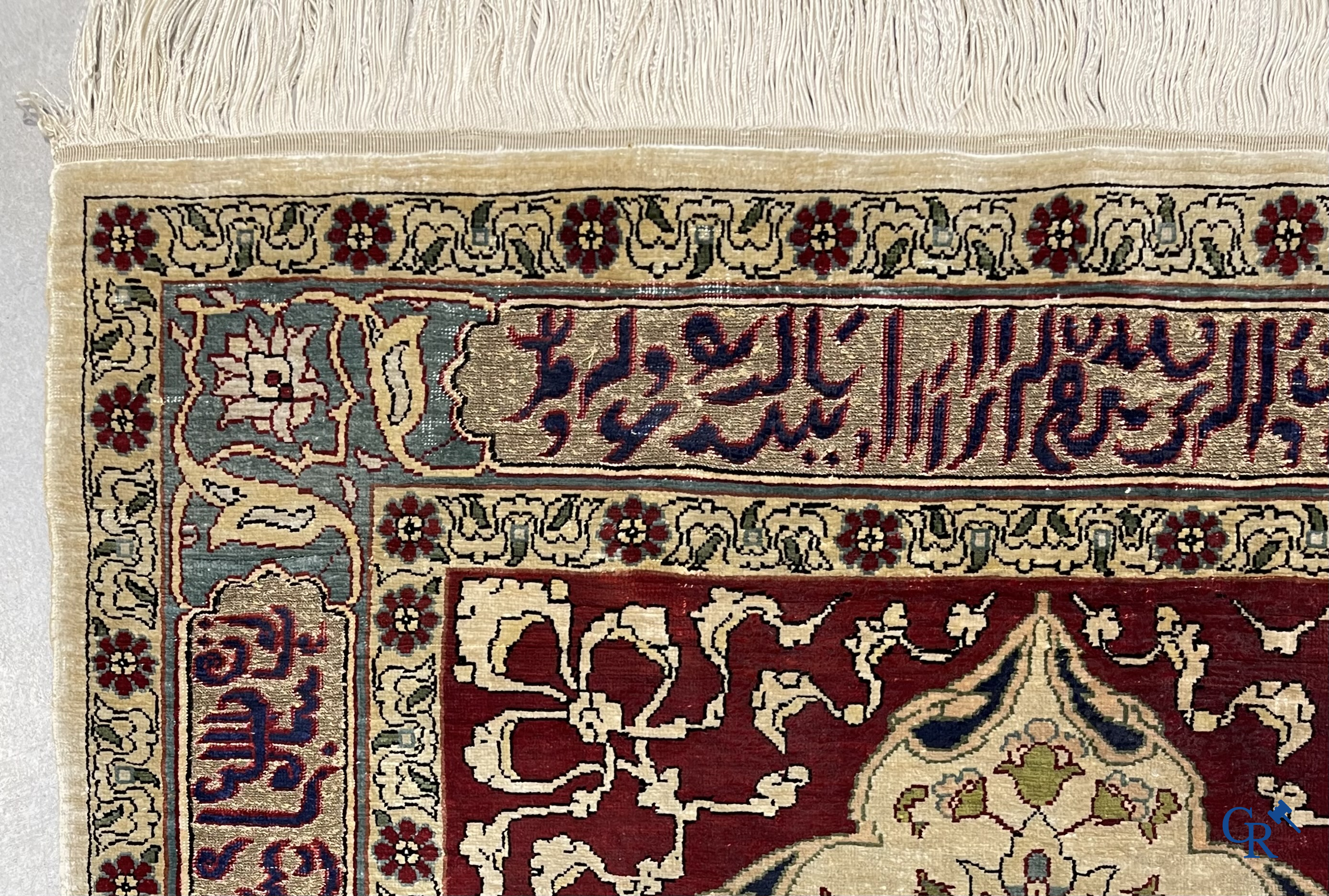 Oosterse tapijten. Een zijden gesigneerd tapijtje met inscripties en bewerkt met gouddraad.