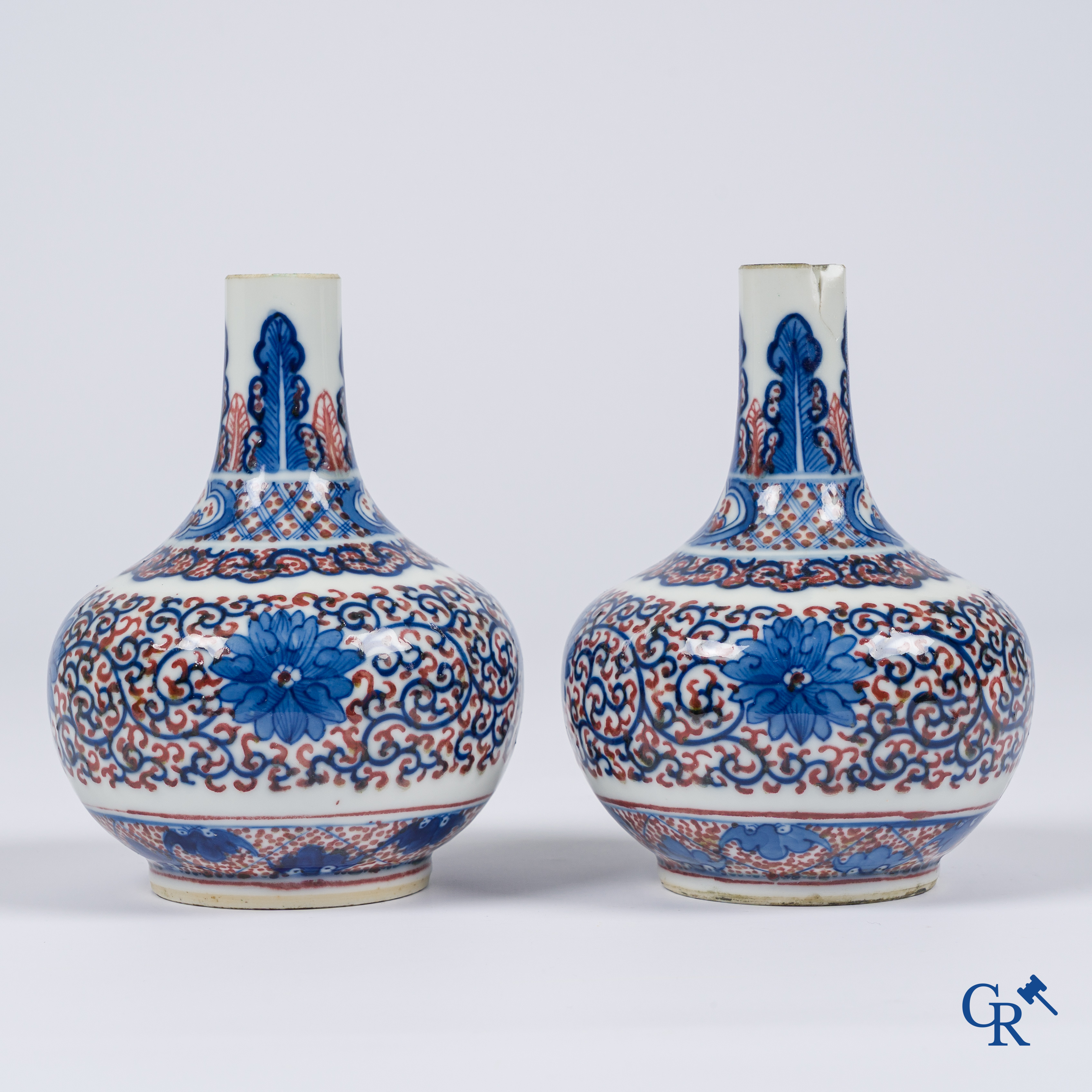 Asian Art, Chinese porcelain. A pair of blue-white and iron-red decorated vases with bats and a dragon bottom mark.