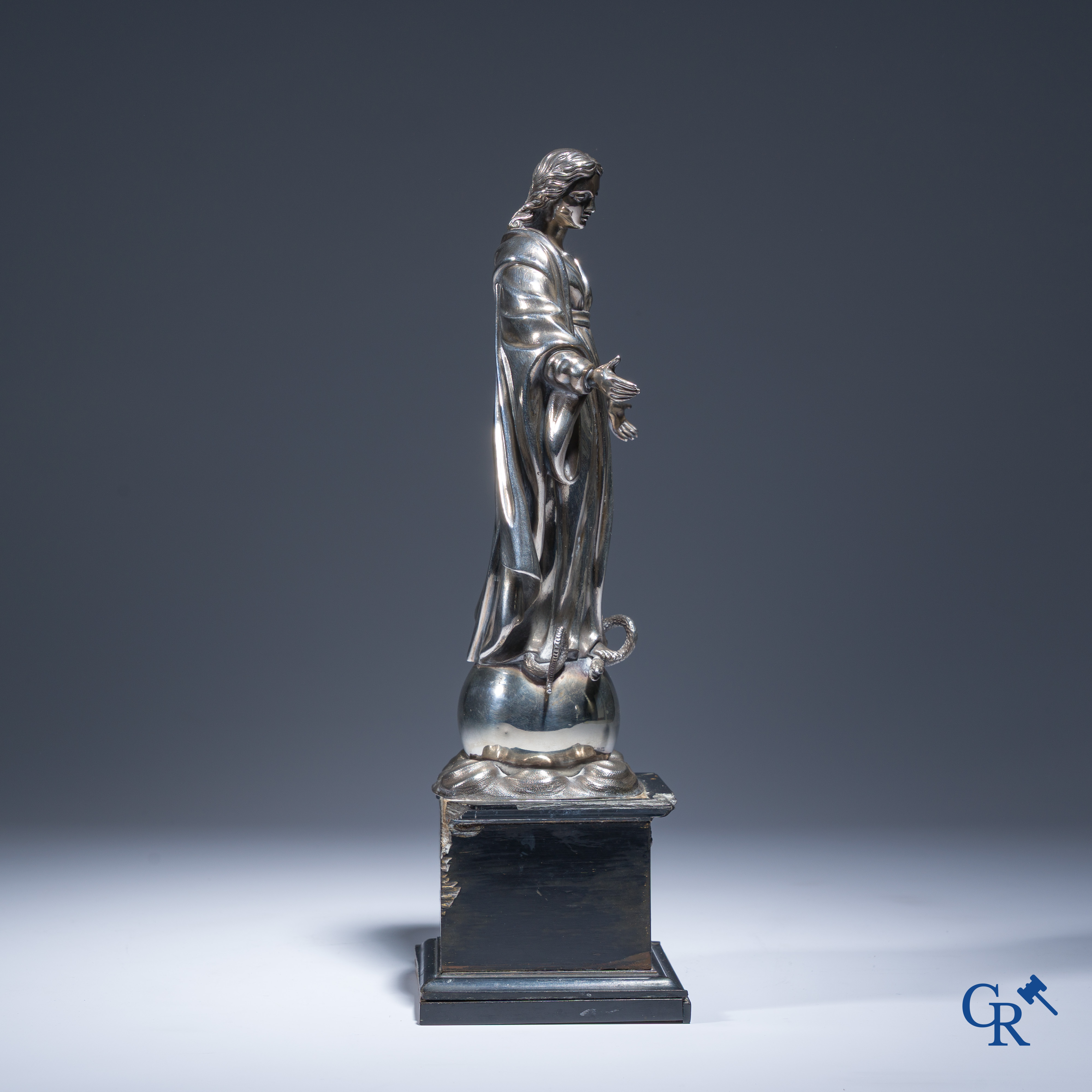 Een zilveren beeld van de Maagd Maria op een zwartgelakte sokkel in perelaar. Keurstempels Vieillard en Cérès.