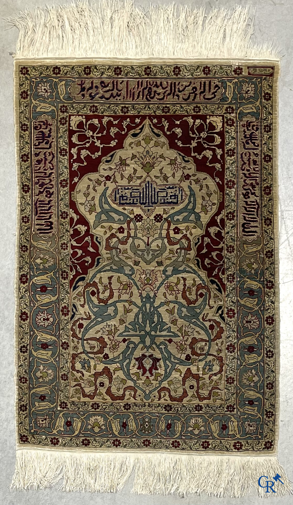 Oosterse tapijten. Een zijden gesigneerd tapijtje met inscripties en bewerkt met gouddraad.