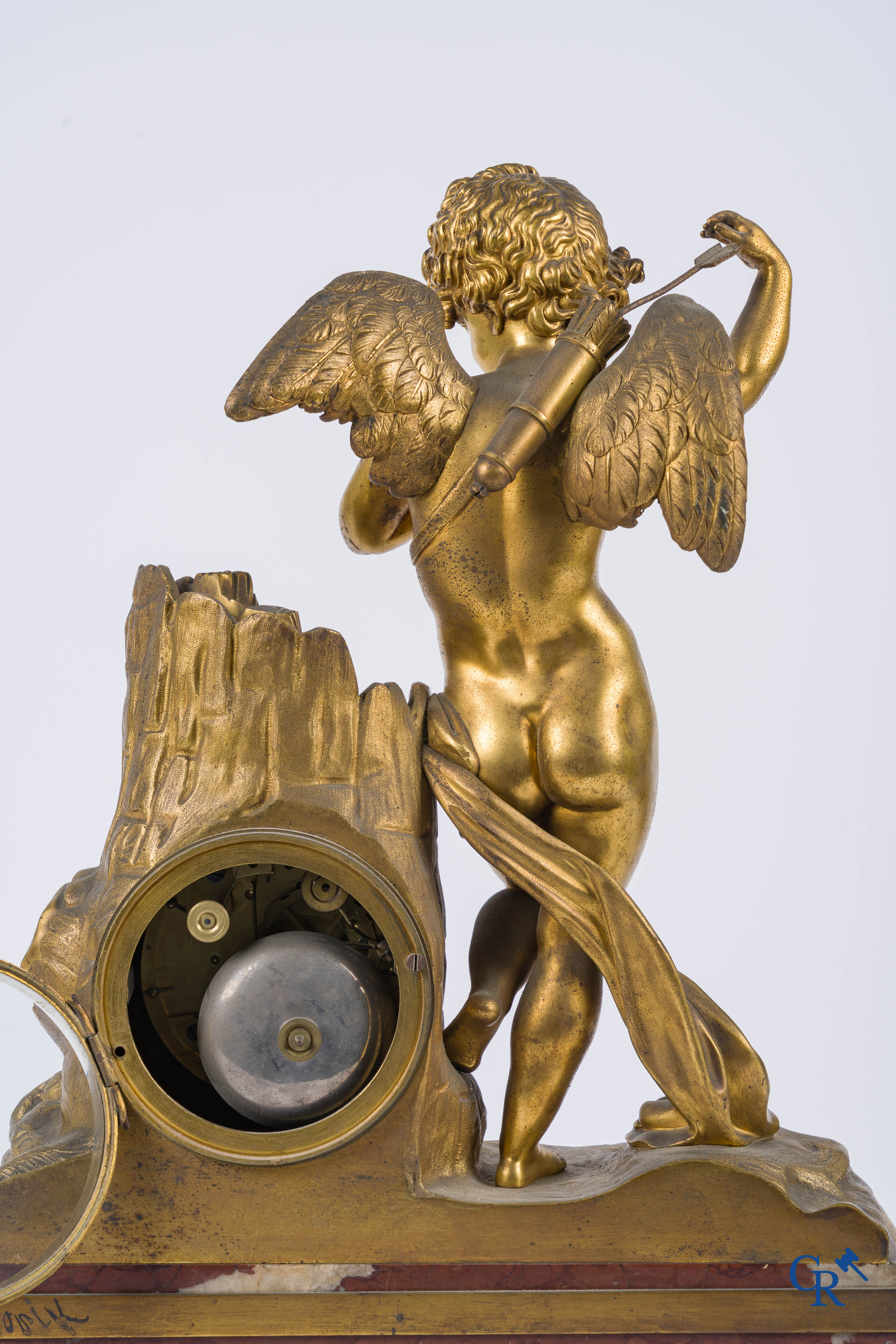 Charles X, pendule en bronze au cupidon finement ciselé et doré. Socle en marbre veiné rouge, vers 1840.