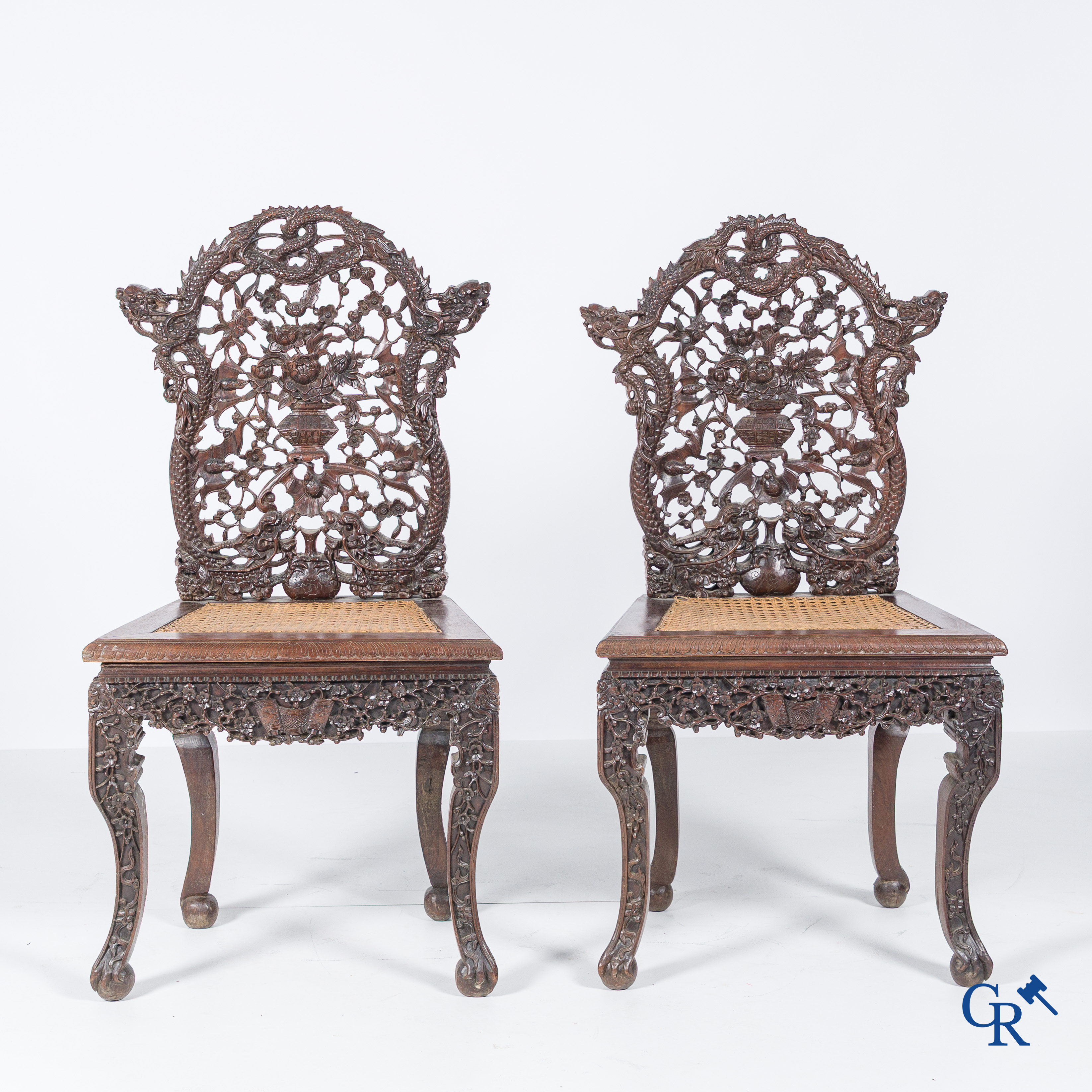 Asian Art, A pair of richly carved chairs with bats, dragons and flowers in Chinese hardwood. 19th century.
