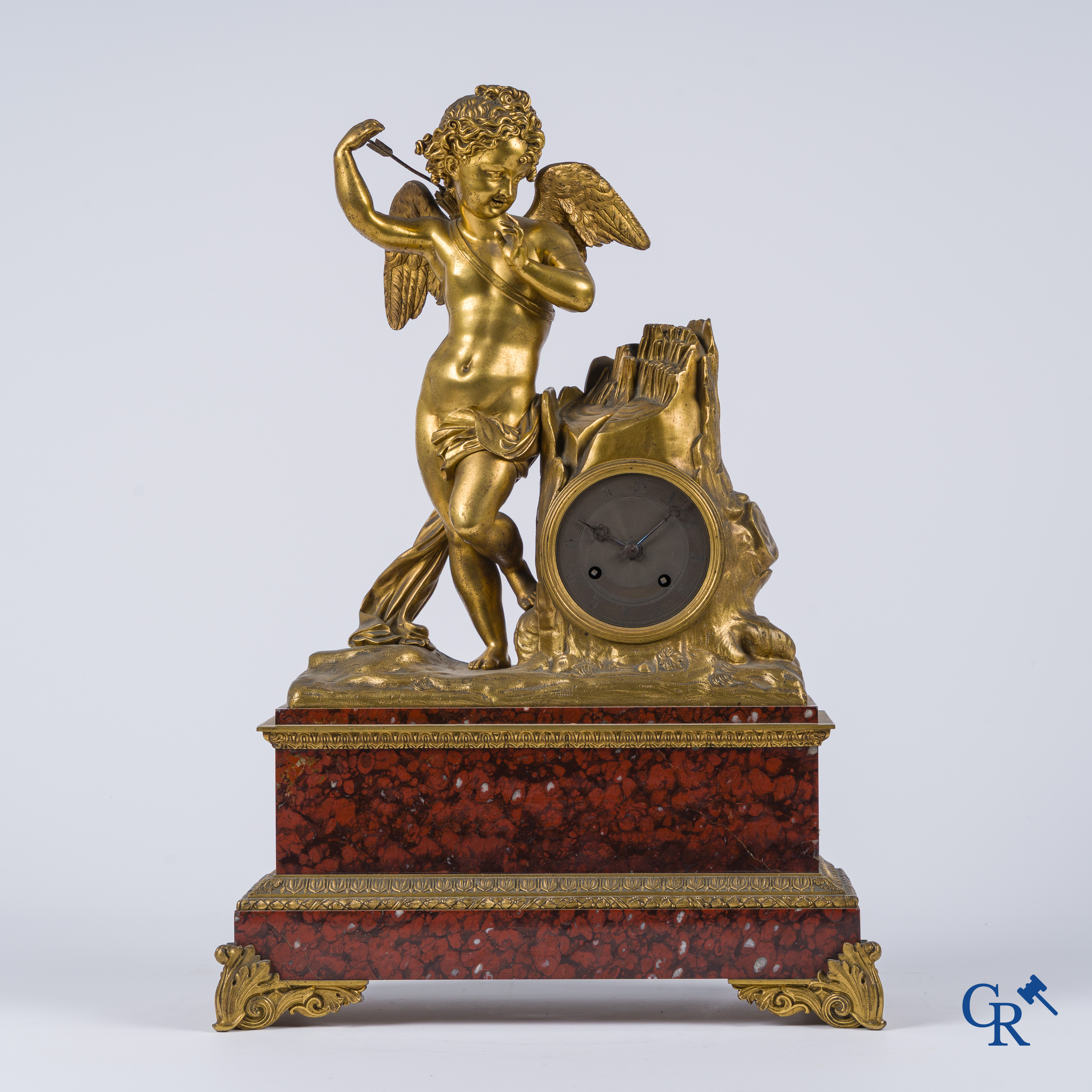Charles X, pendule en bronze au cupidon finement ciselé et doré. Socle en marbre veiné rouge, vers 1840.
