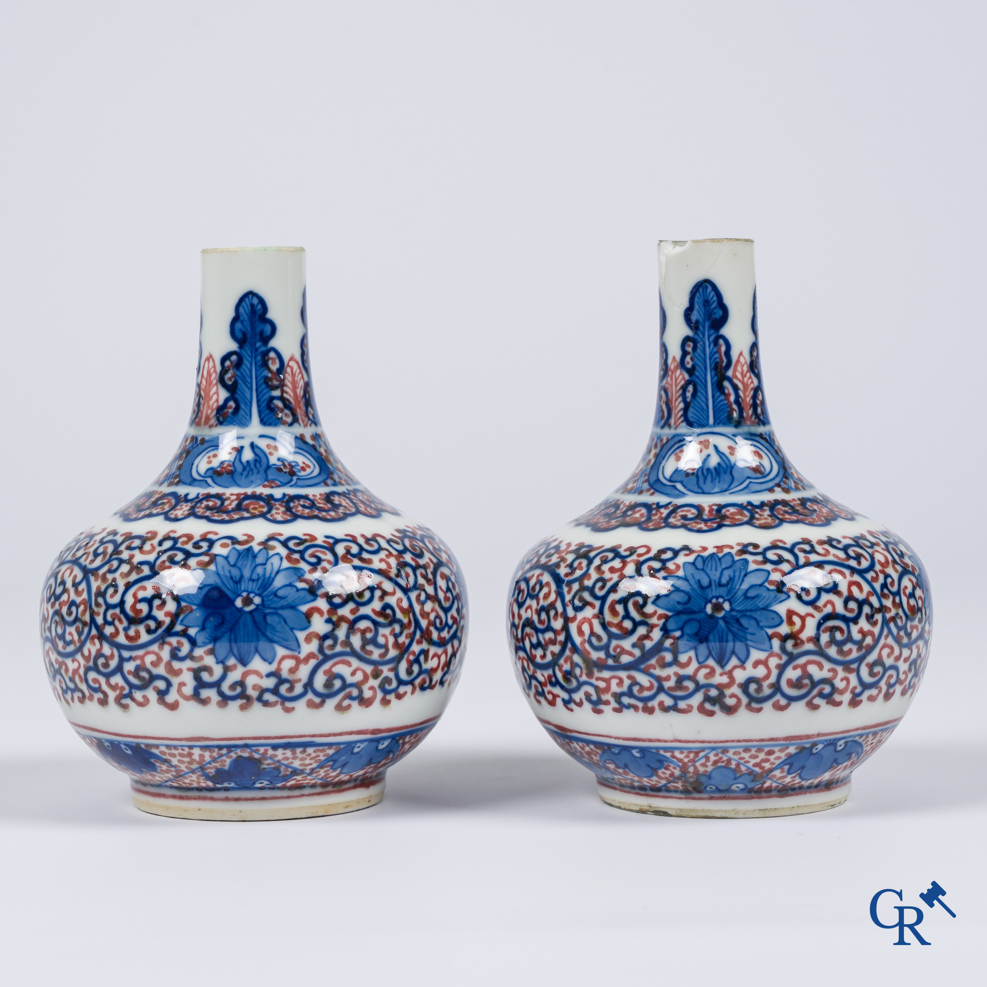 Asian Art, Chinese porcelain. A pair of blue-white and iron-red decorated vases with bats and a dragon bottom mark.