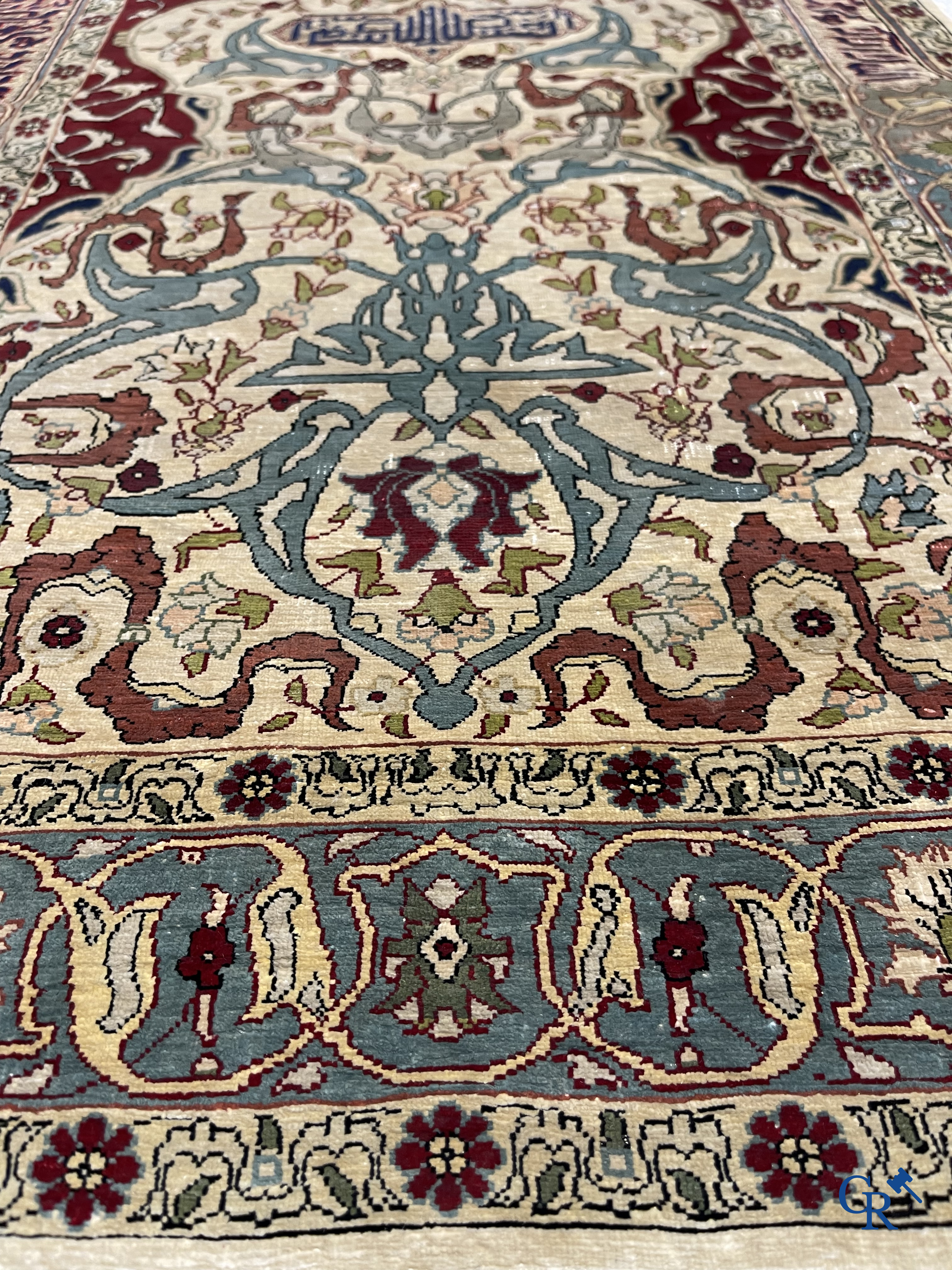 Oosterse tapijten. Een zijden gesigneerd tapijtje met inscripties en bewerkt met gouddraad.