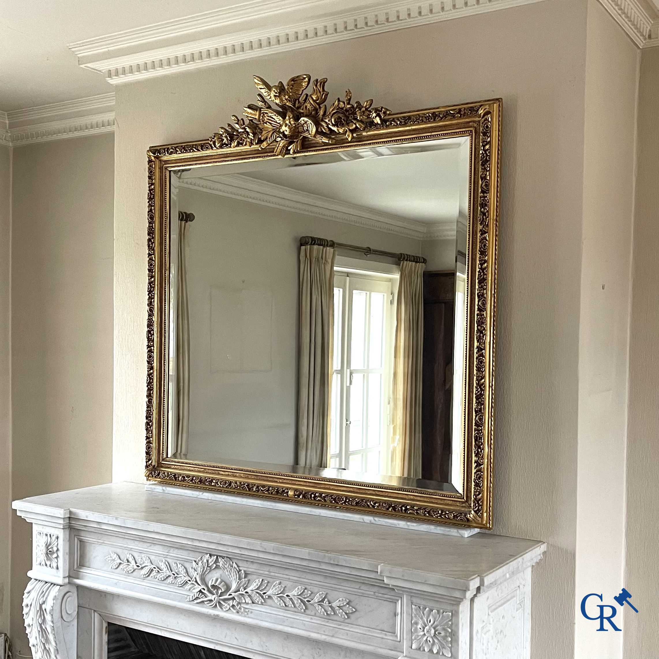 A large gilded fireplace mirror in LXVI style. Circa 1920.