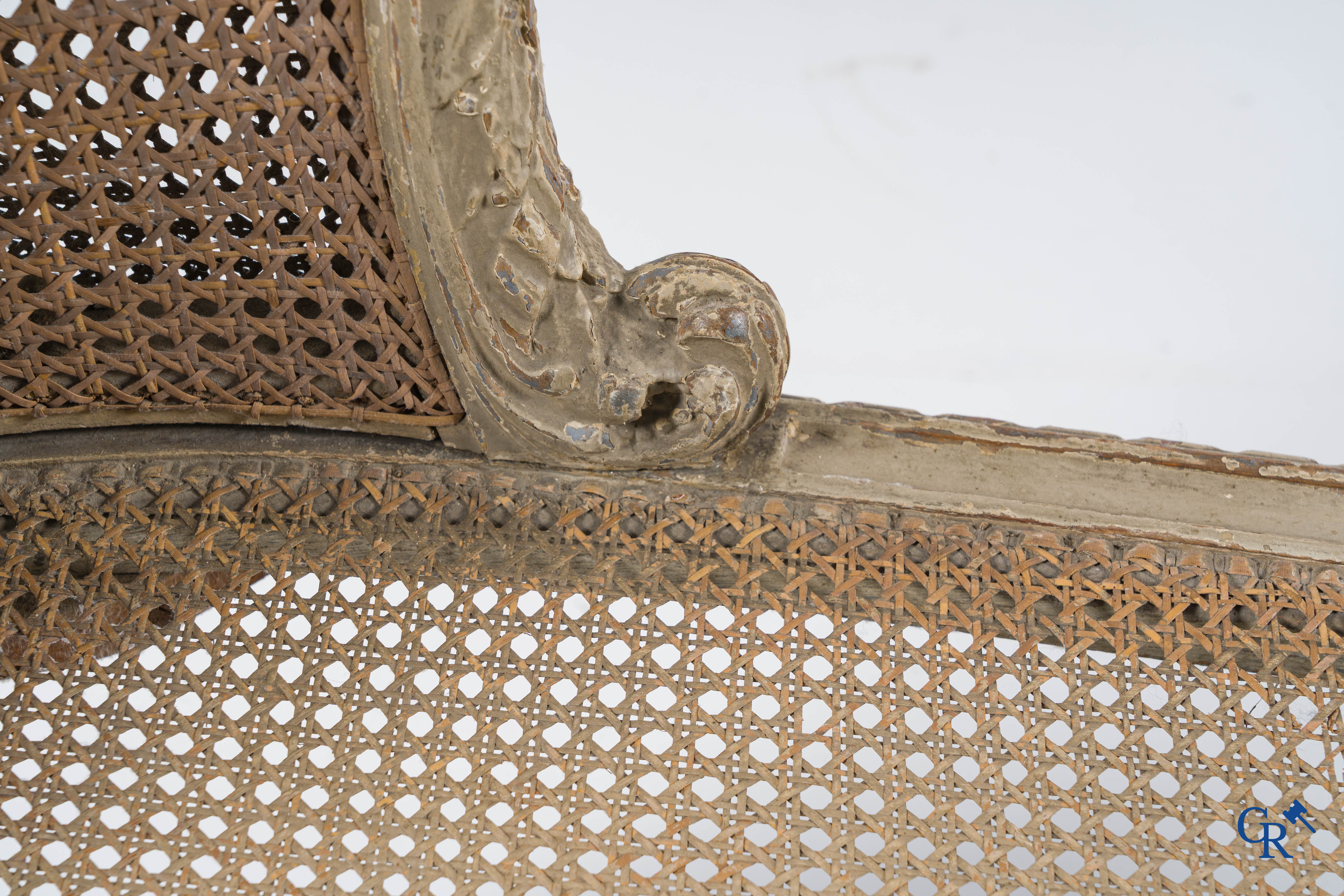 Epoque Louis XVI. Une banquette LXVI en bois sculpté à patine grise avec cannage. Fin du XVIIIème siècle.