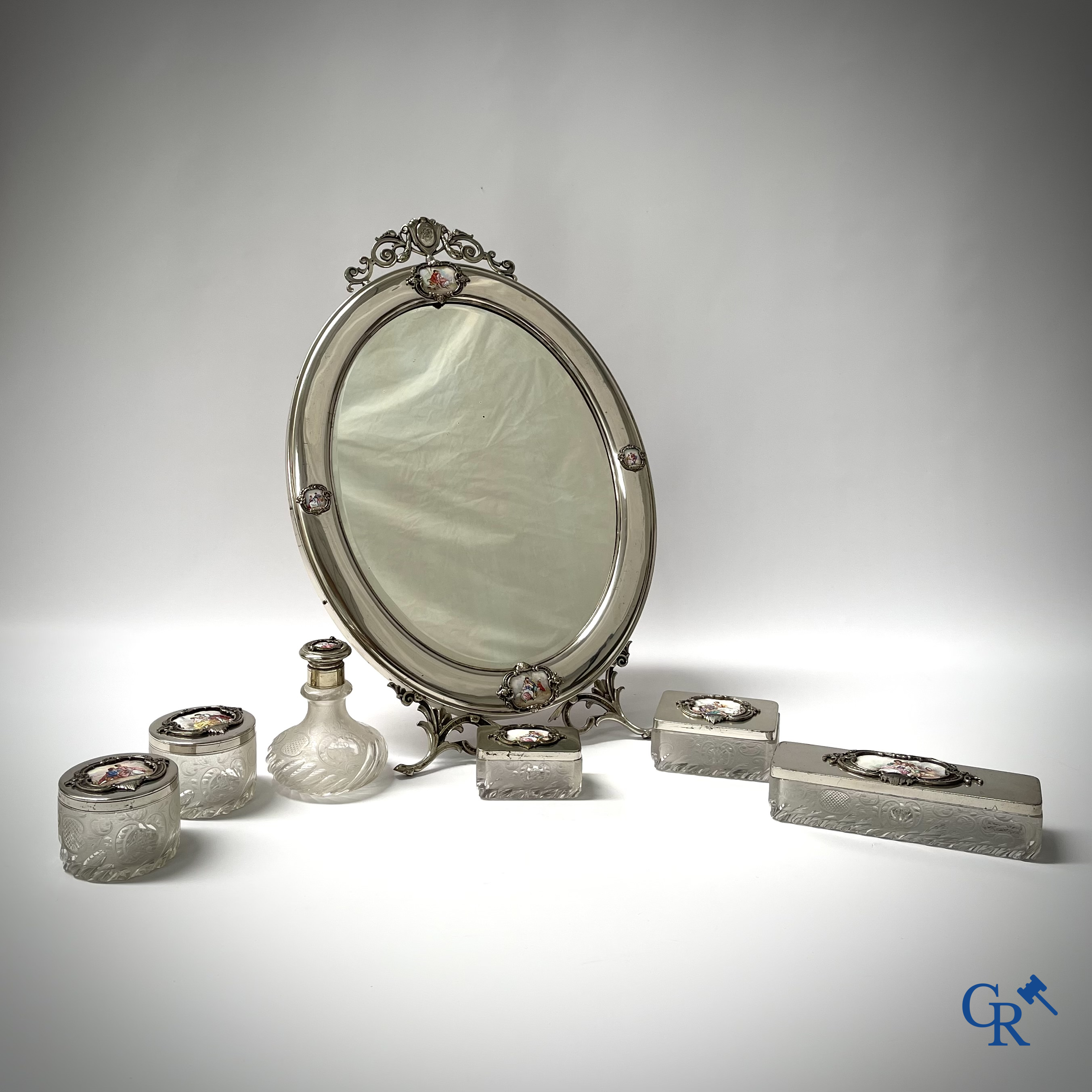 Un ensemble de toilette 7 pièces en métal argenté, cristal finement taillé et plaques émaillées.