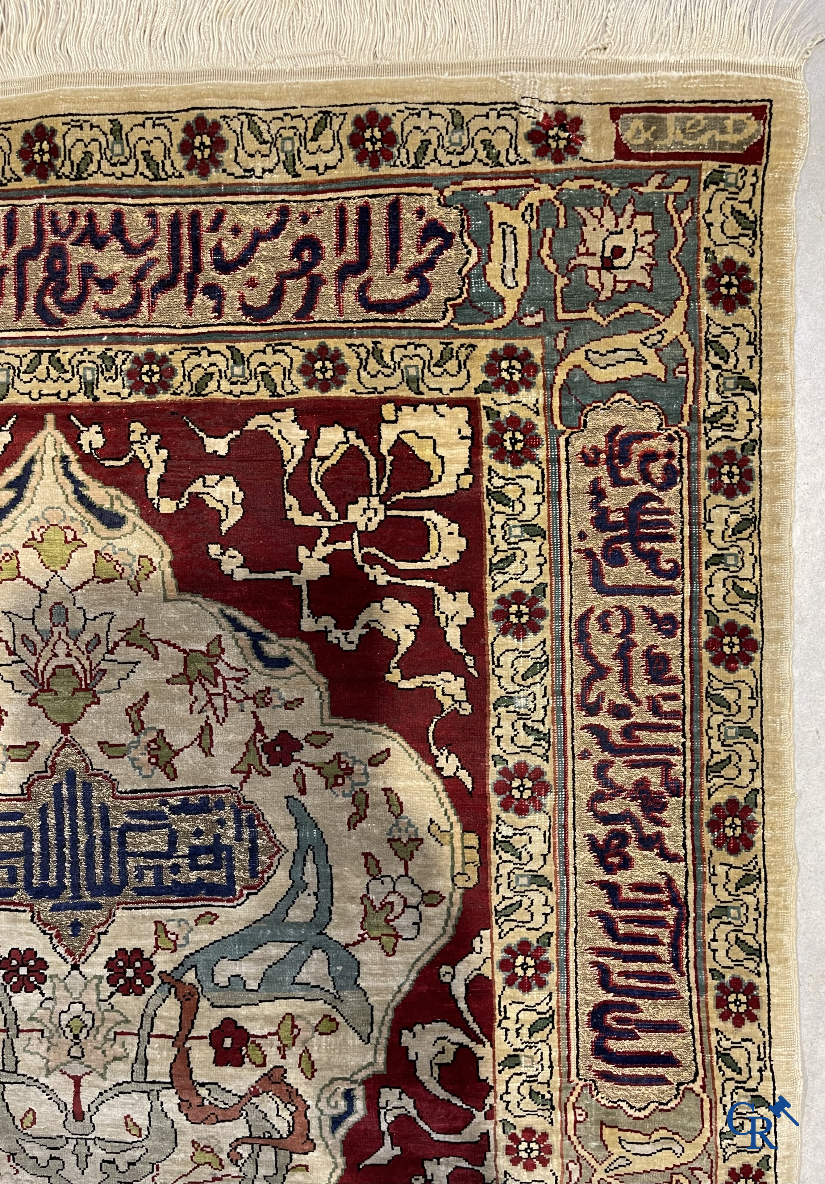 Oosterse tapijten. Een zijden gesigneerd tapijtje met inscripties en bewerkt met gouddraad.