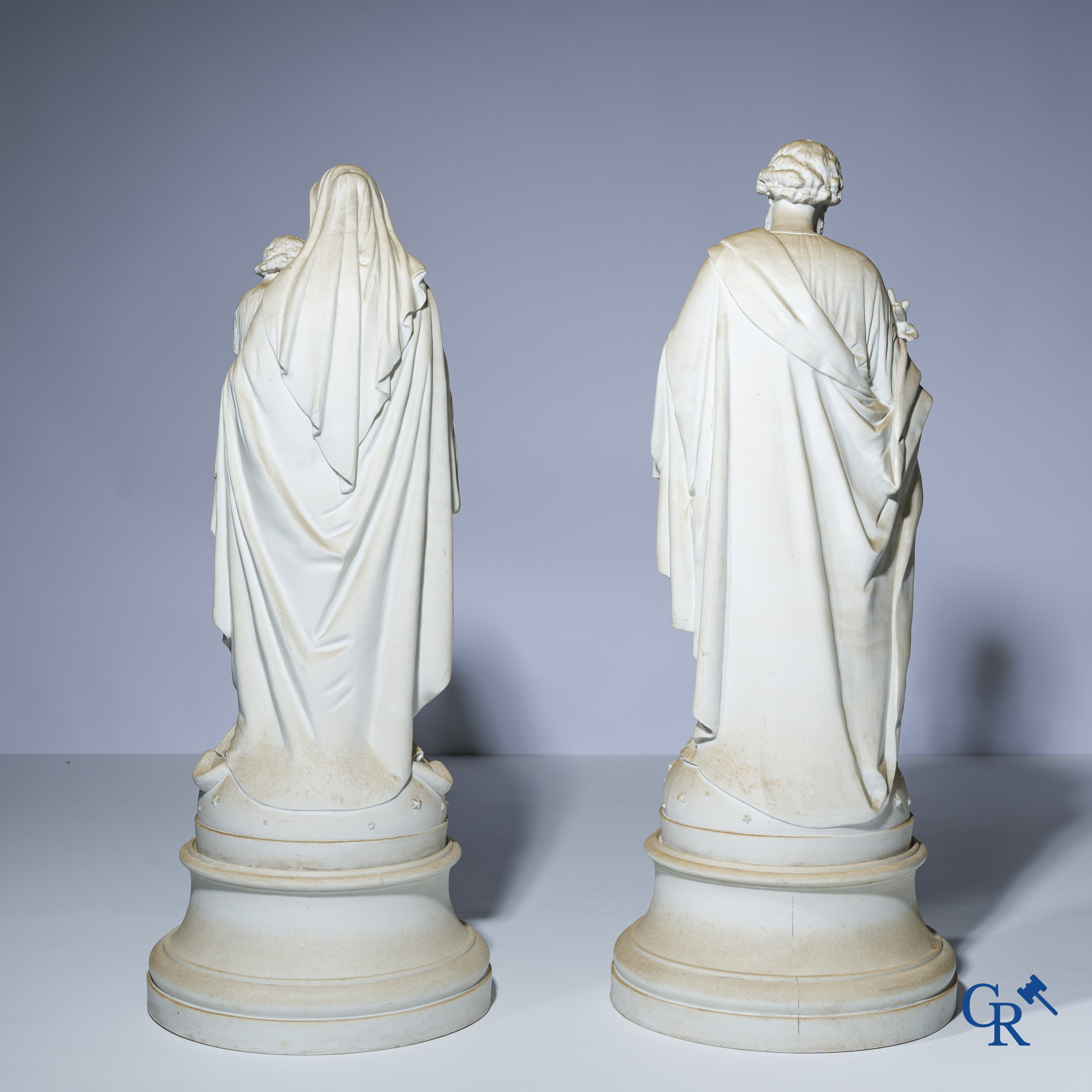 Religieuze objecten, een paar imposante beelden in witte biscuit op een losse sokkel. 19e eeuw.