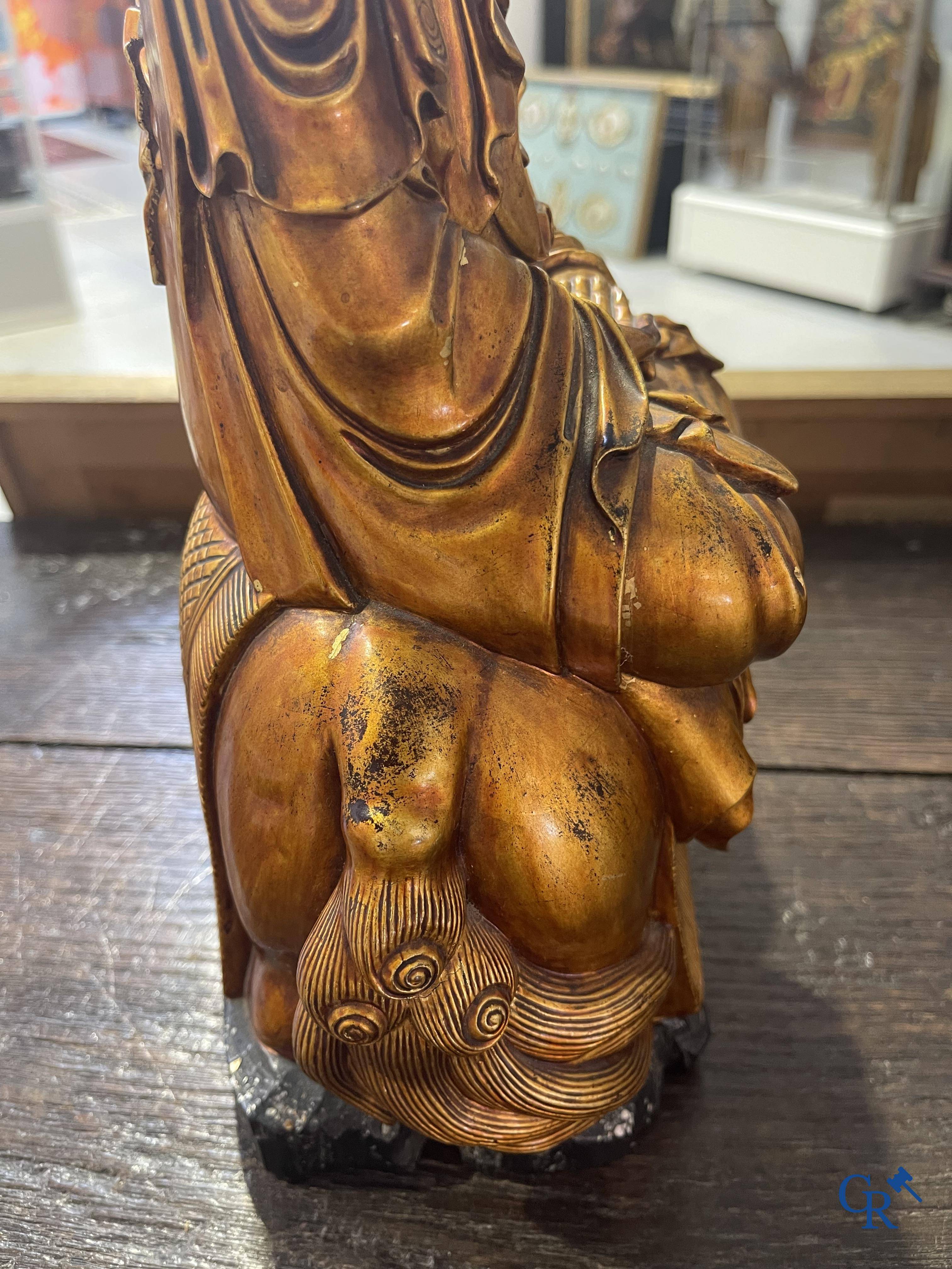 Asian Art: A Chinese sculpture of Vaishravana on a Buddhist lion in lacquered and gilded wood. 19th century.